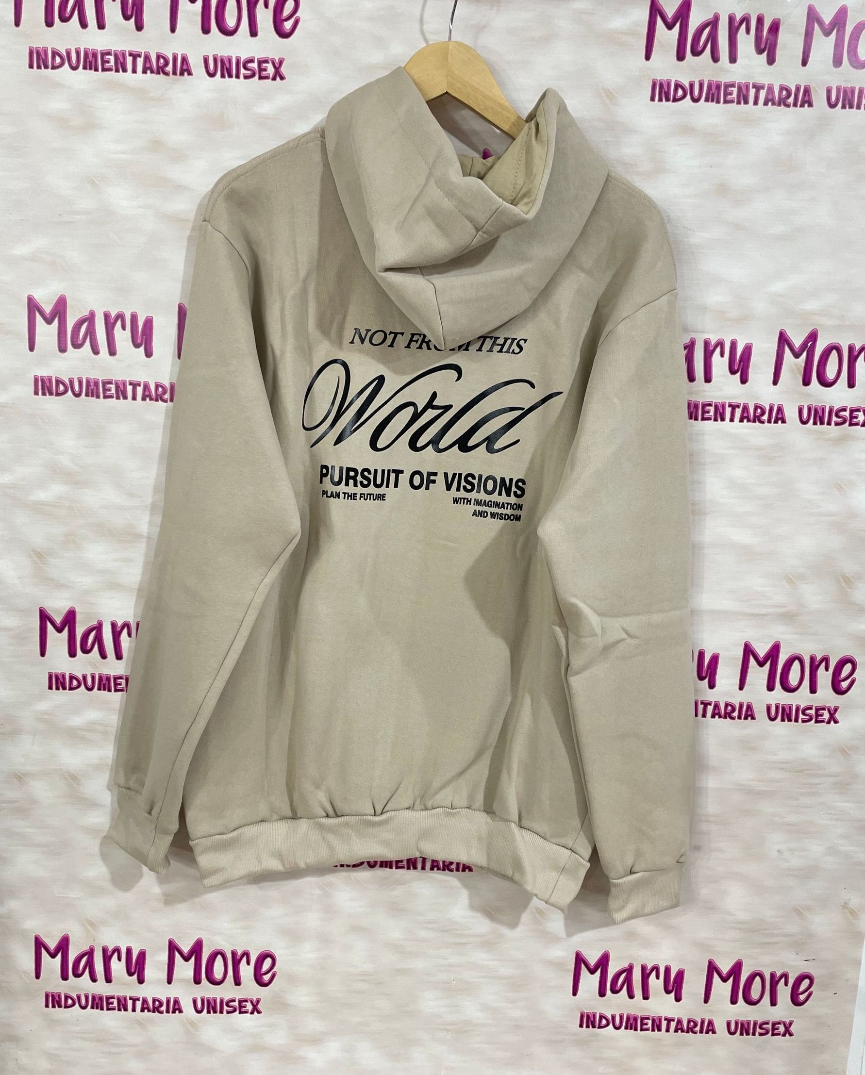 Una sudadera con capucha está colgada en una percha frente a un cartel que dice Mary More.