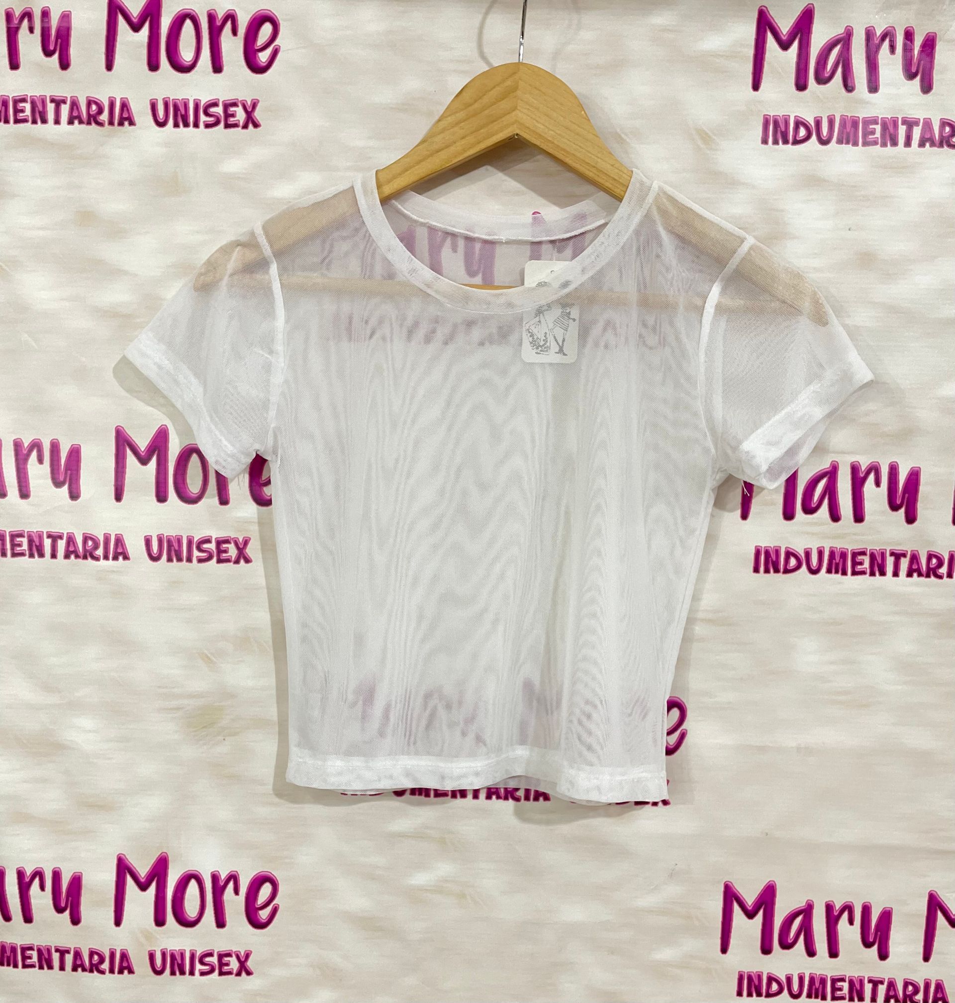 Un top corto de malla negra está colgado en una percha