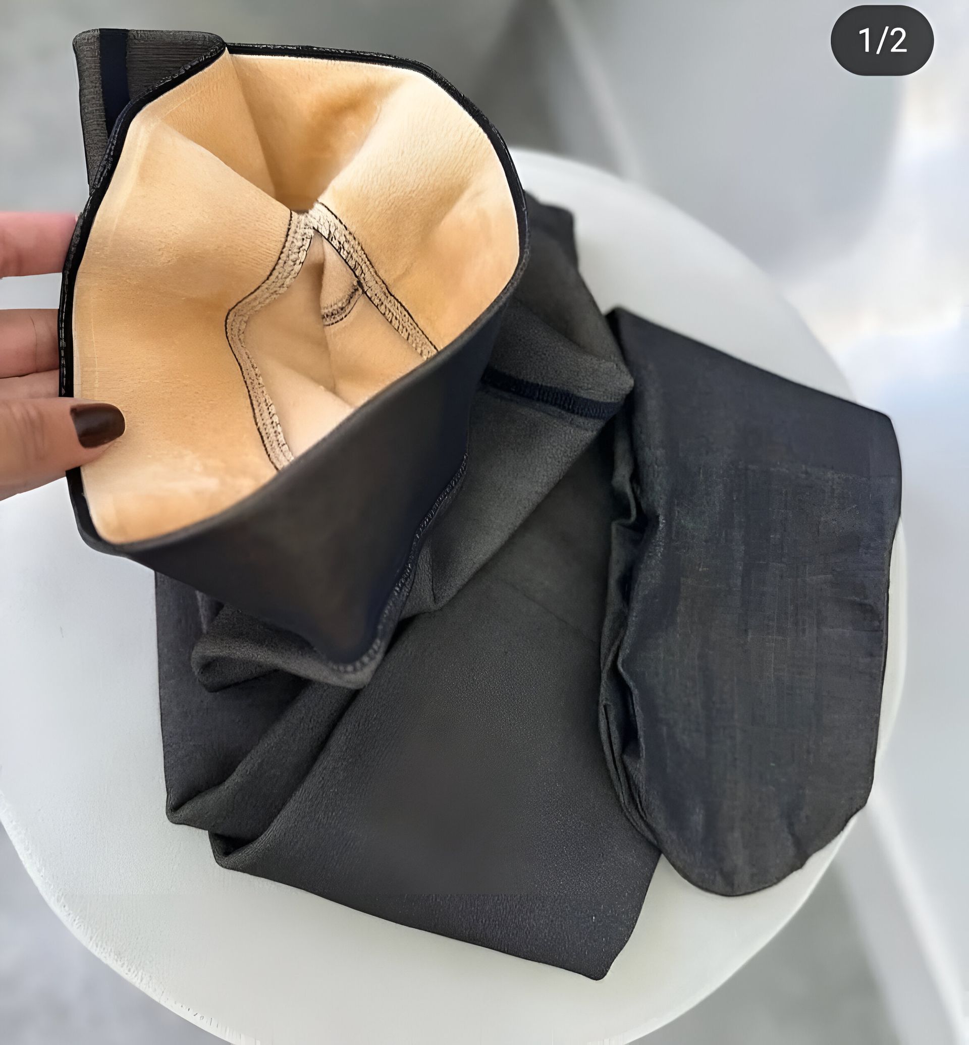 Una mujer con medias negras está acostada sobre una almohada blanca.