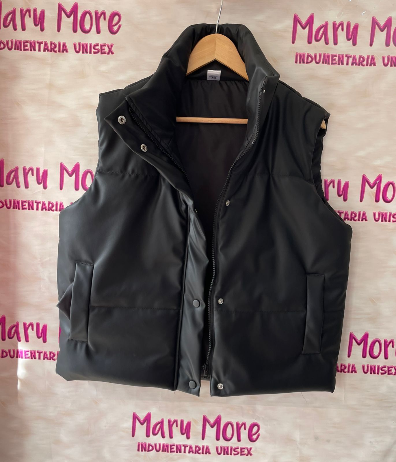 Una mujer lleva un chaleco negro y pantalones negros.