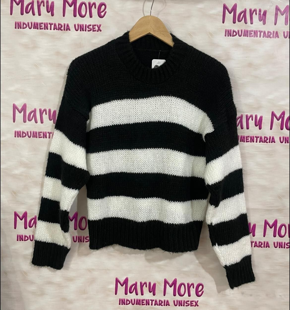 Dos suéteres de rayas cuelgan frente a un cartel que dice Mary More.