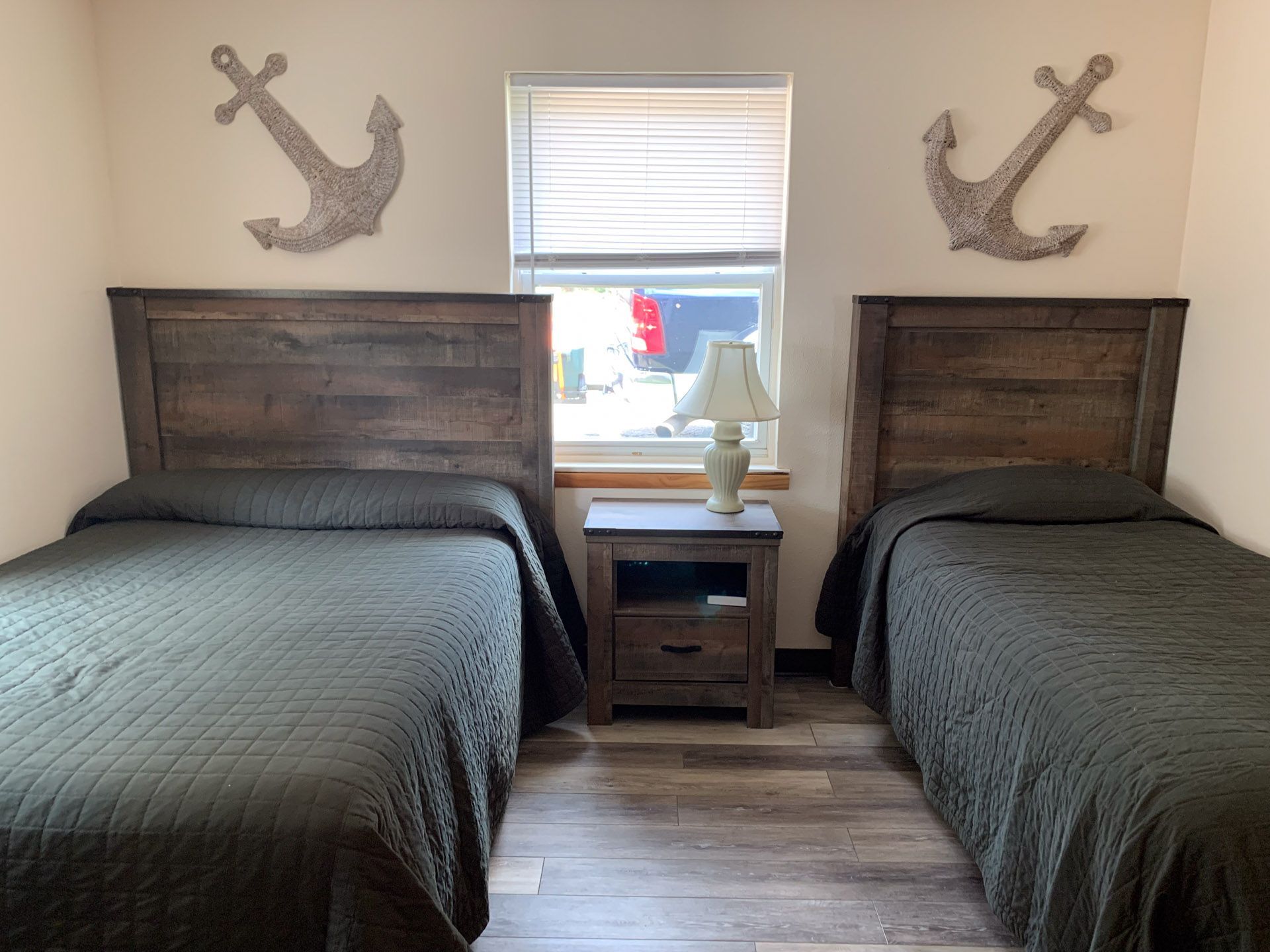 A bedroom with two beds and two anchors on the wall