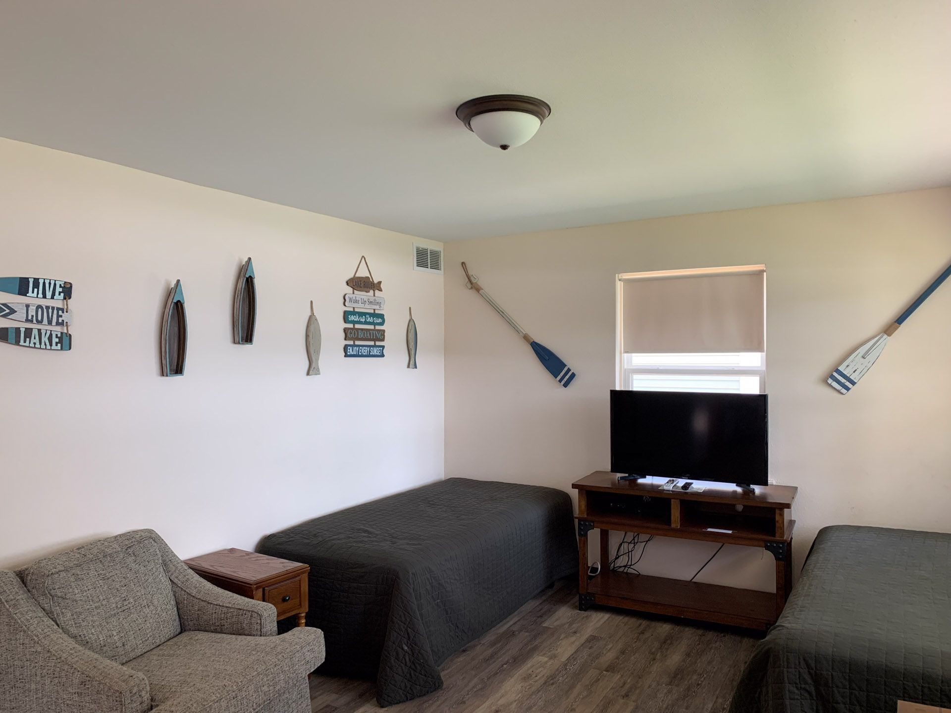 A living room with two beds and a flat screen tv