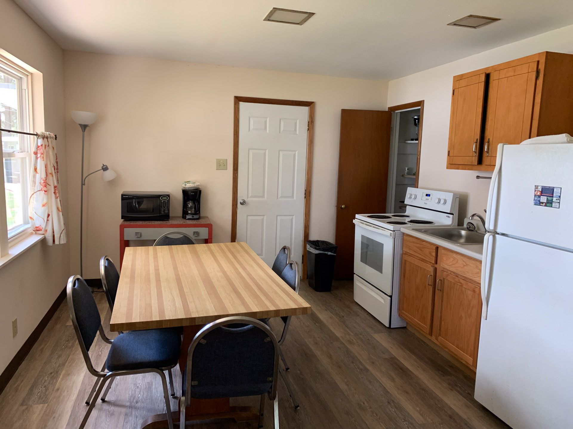A kitchen with a table and chairs and a refrigerator