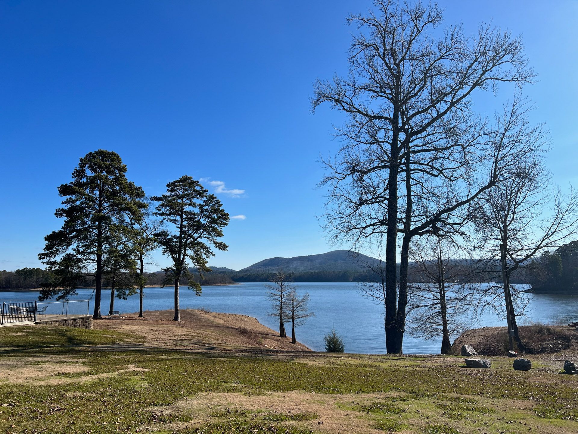 A lake with trees in the foreground and mountains in the background