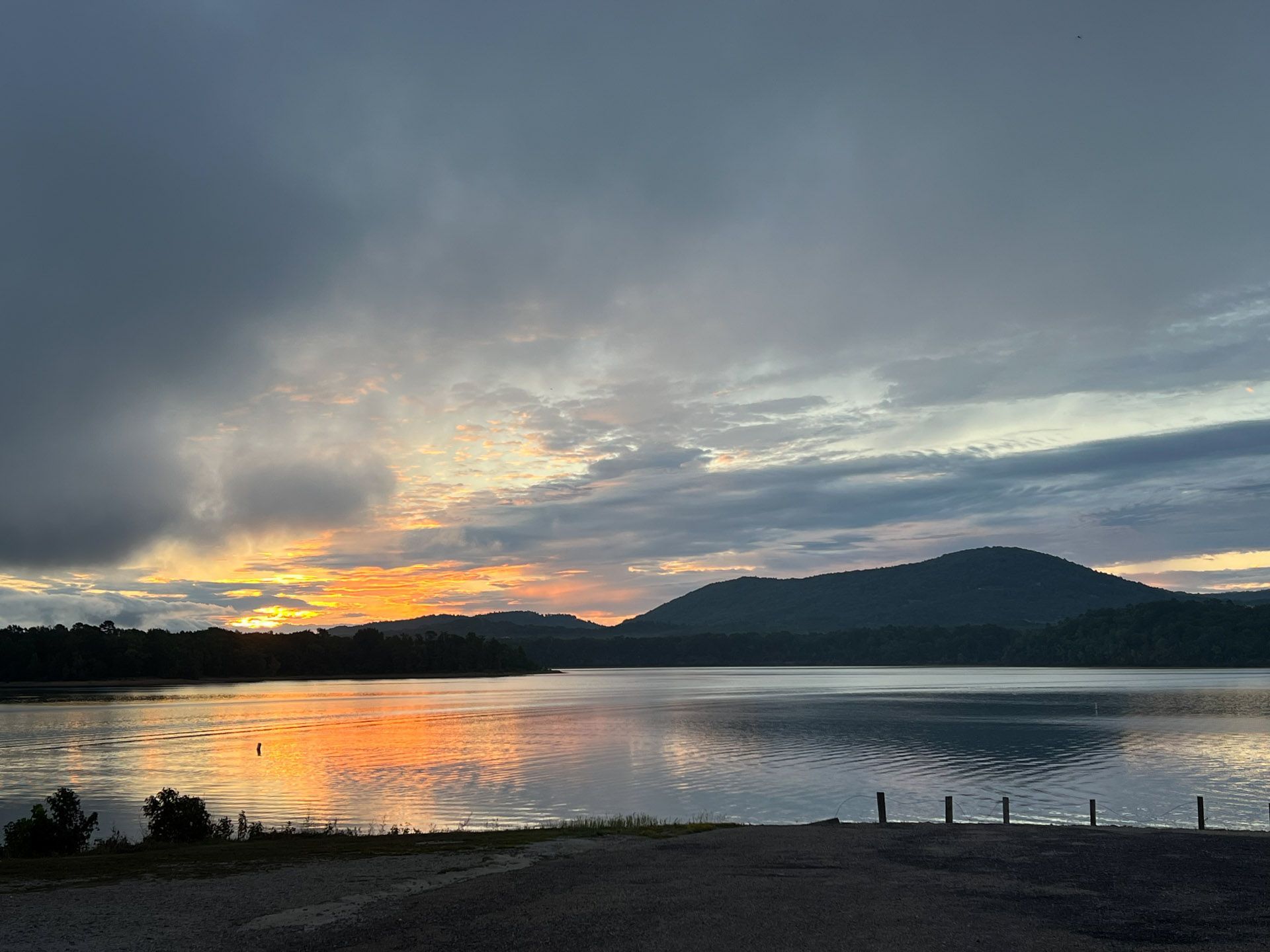 A sunset over a lake with mountains in the background