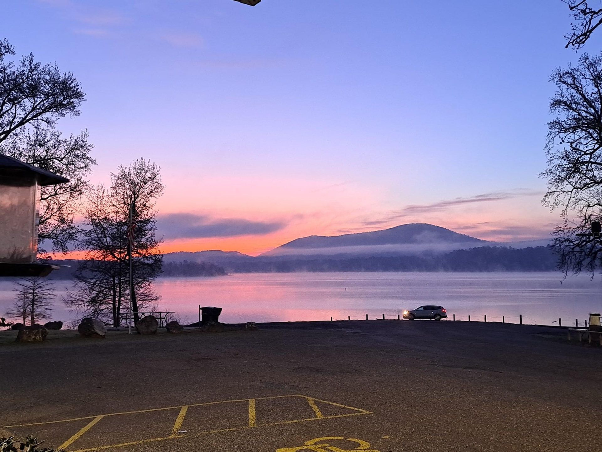 A sunset over a body of water with the word utility written on the ground