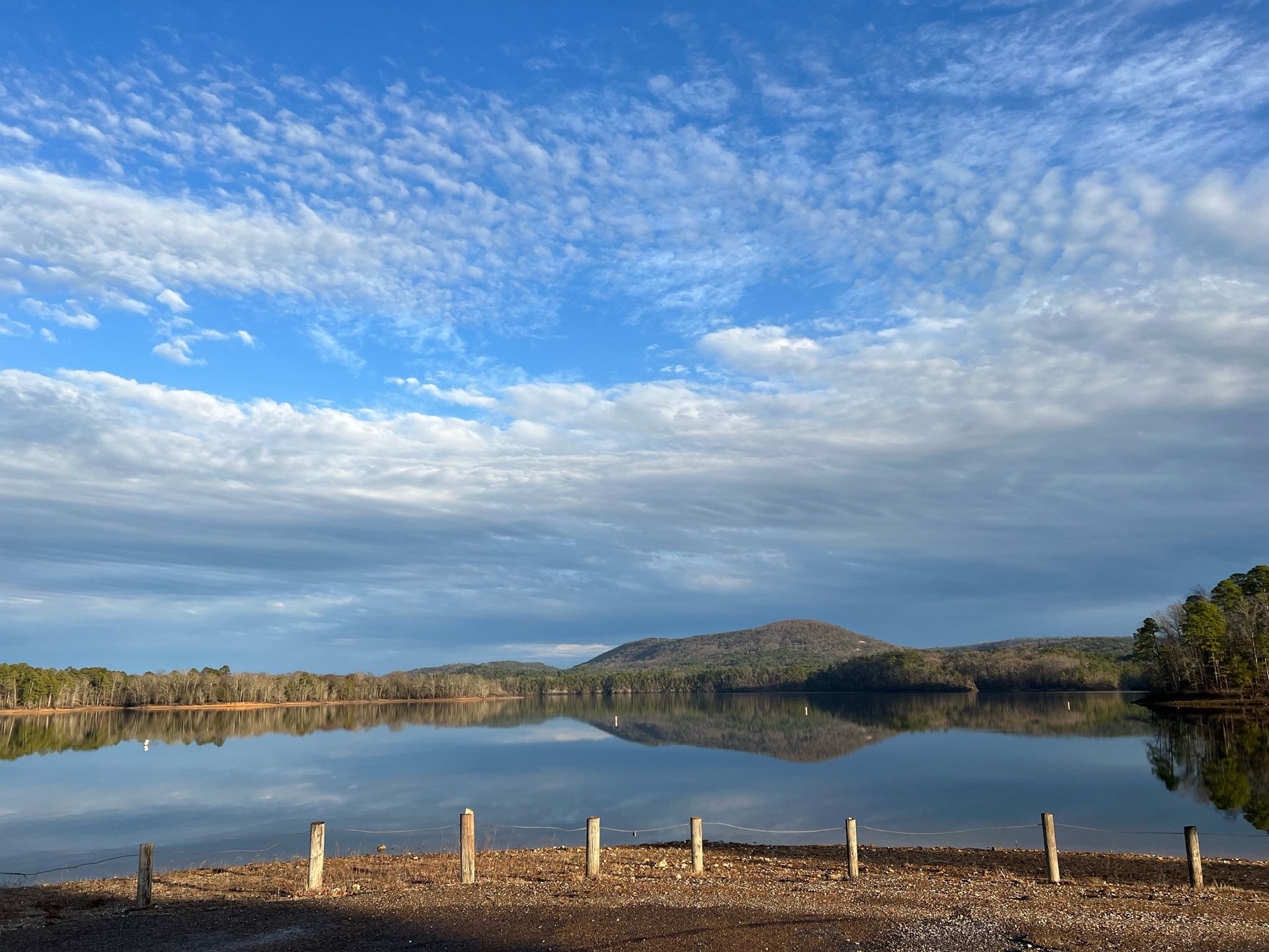 A lake with mountains in the background and a blue sky with clouds