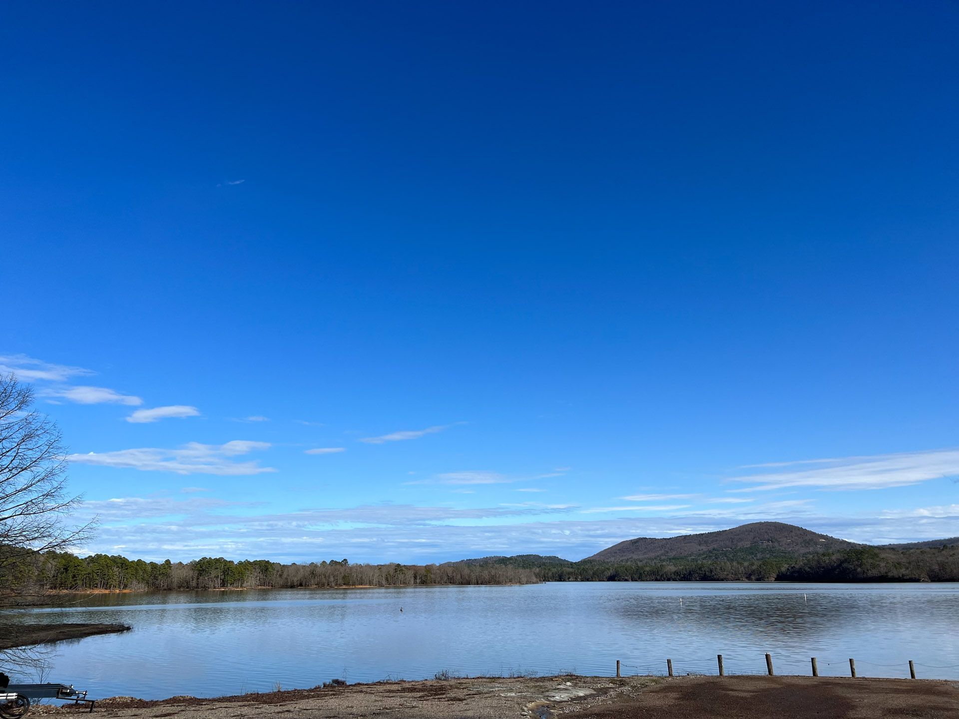 A lake with mountains in the background and a blue sky