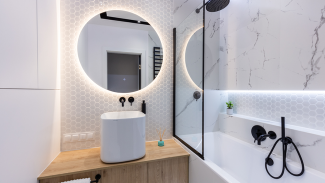 A bathroom with a sink , bathtub , shower and mirror.