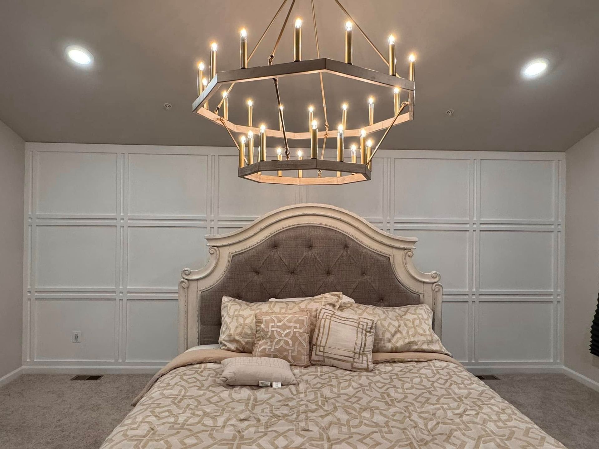 A bedroom with a bed and a chandelier hanging from the ceiling.
