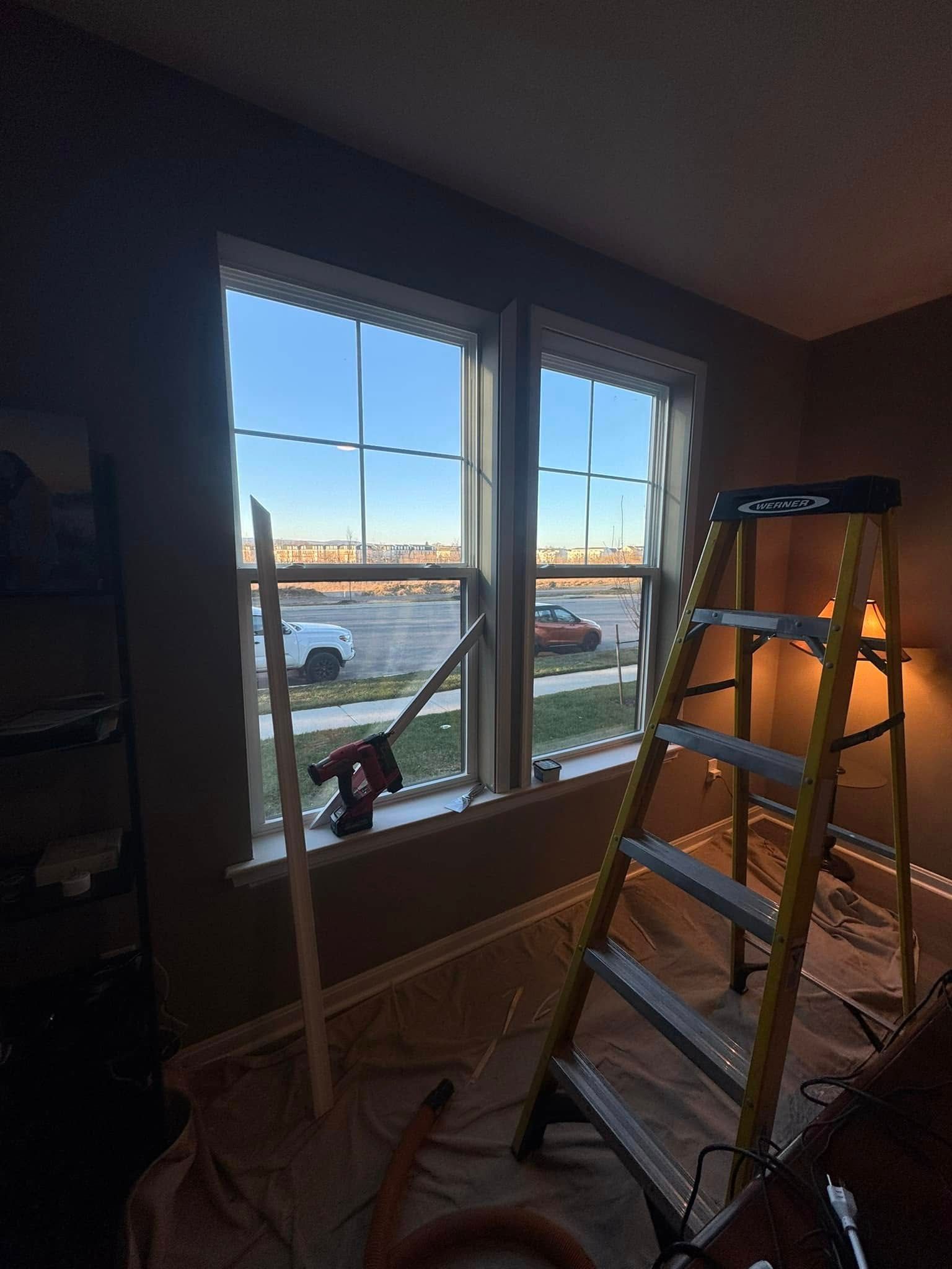 A ladder is sitting in front of a window in a room.