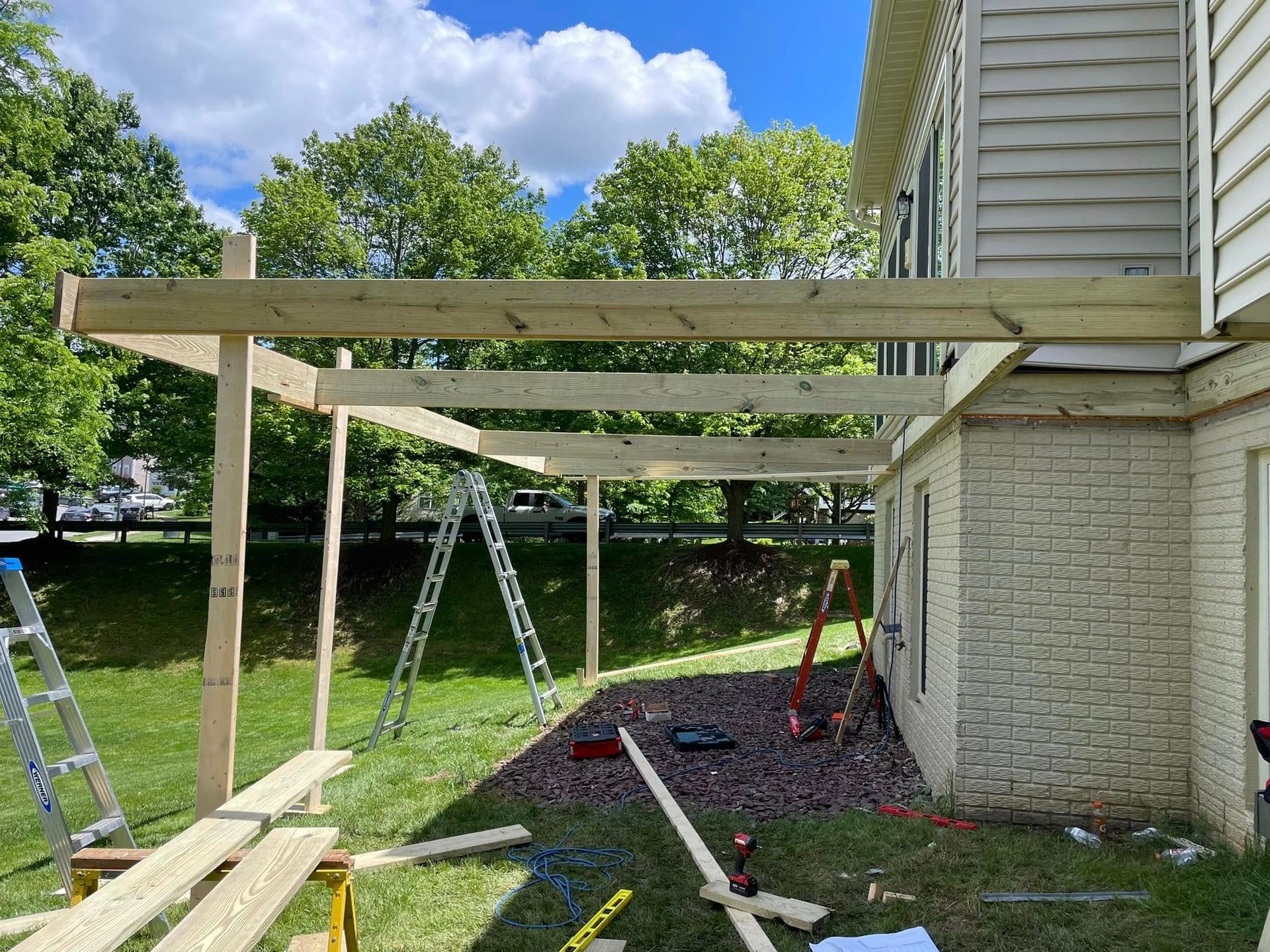 A wooden deck is being built on the side of a house.