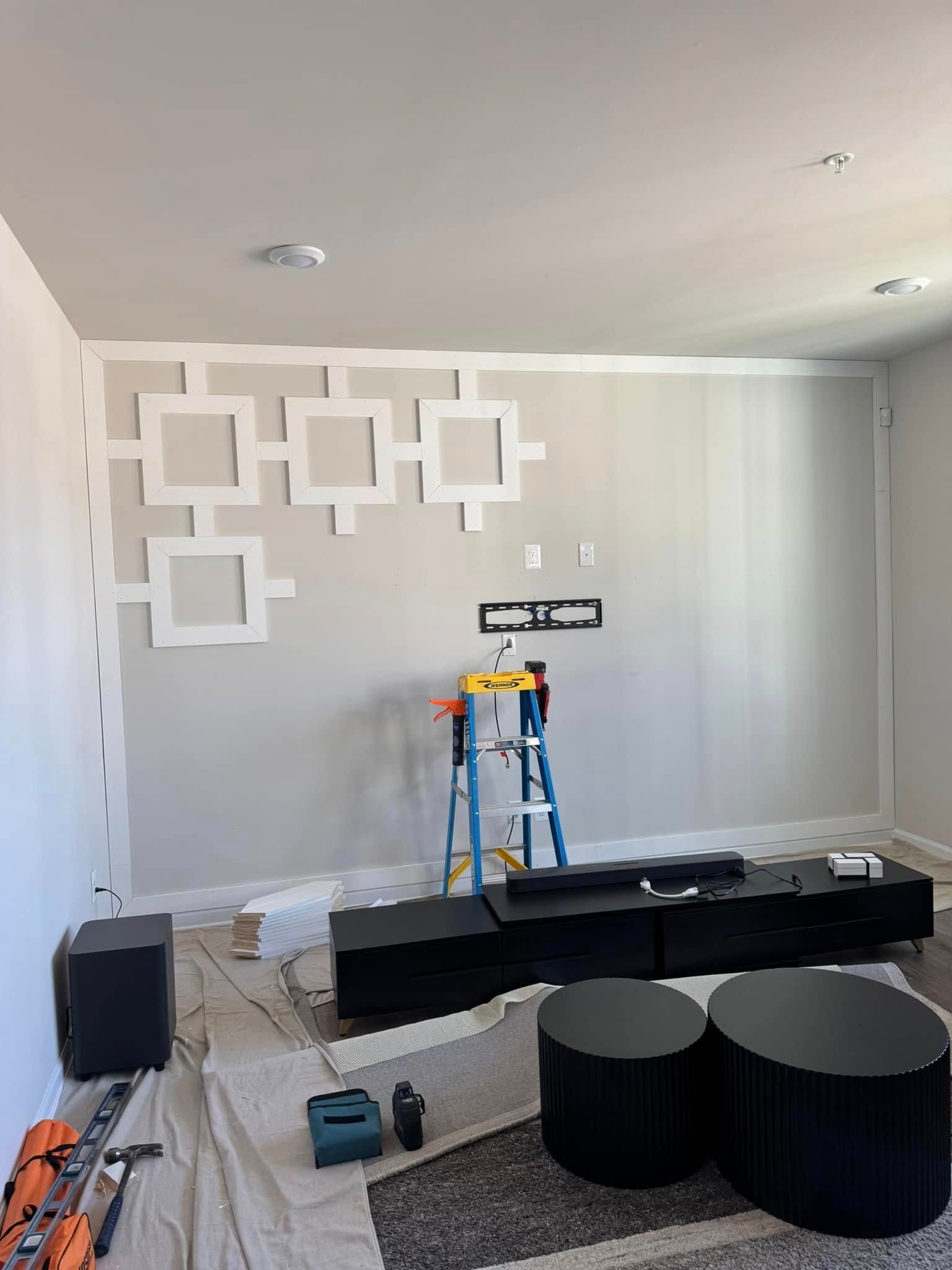 A living room is being remodeled with a ladder and ottomans.