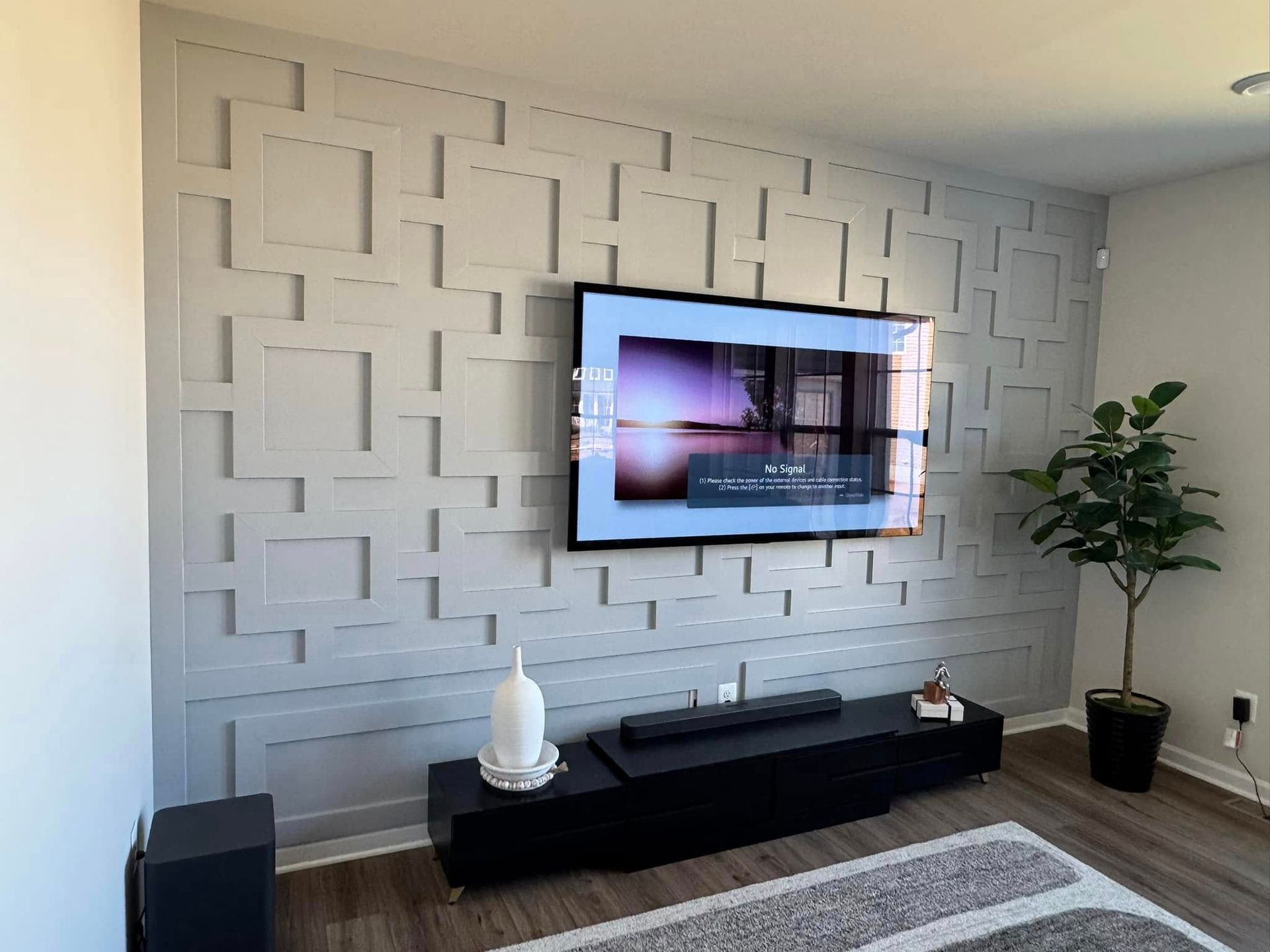A living room with a flat screen tv mounted to the wall.