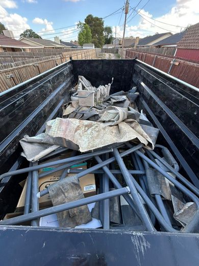 A dumpster filled with a lot of metal junk.