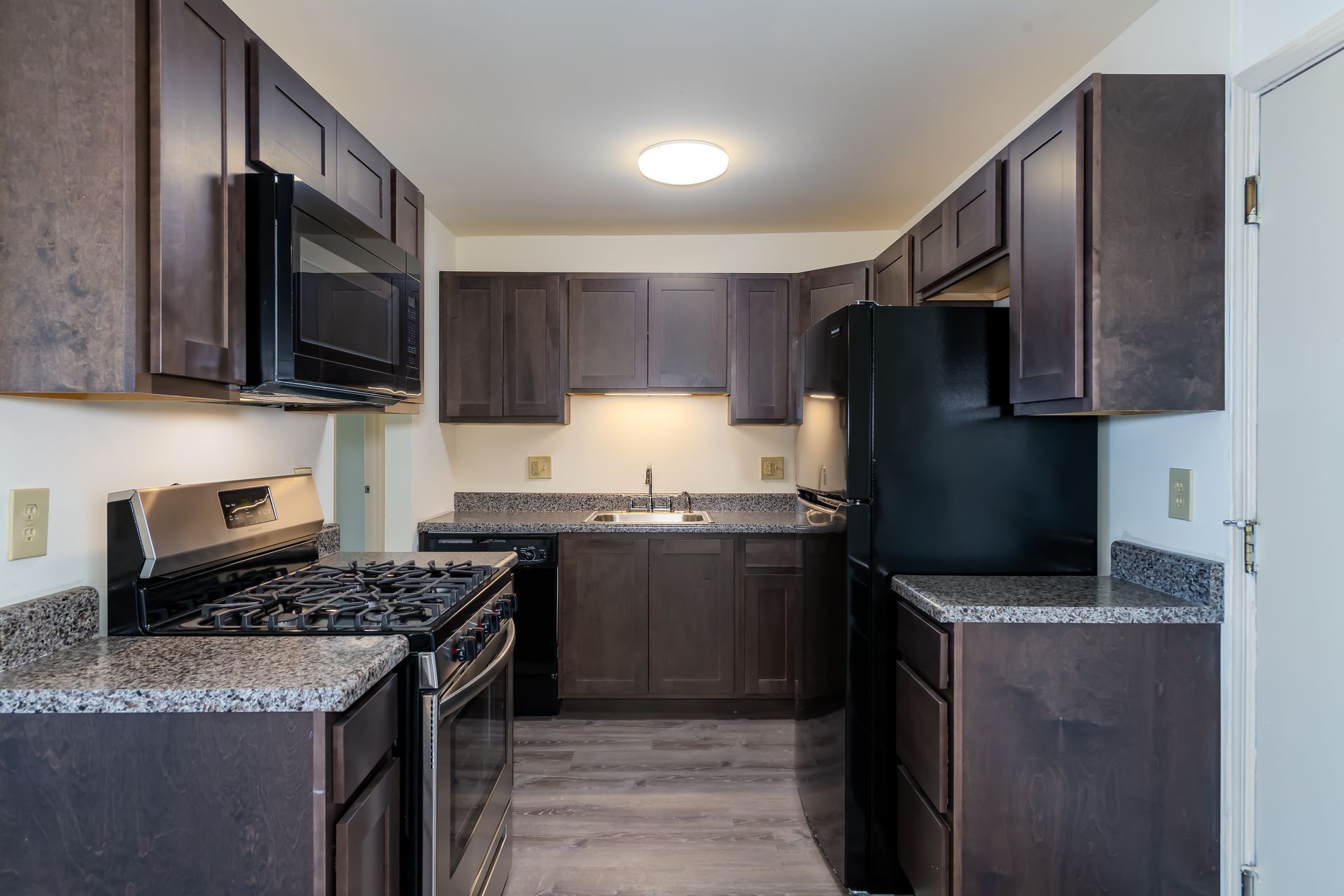 A kitchen with brown cabinets and black appliances