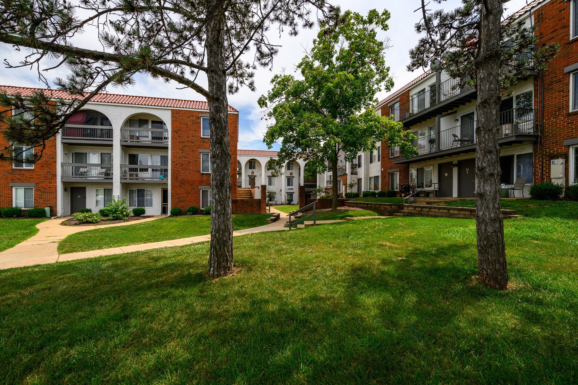 A large apartment building with a lush green lawn in front of it.