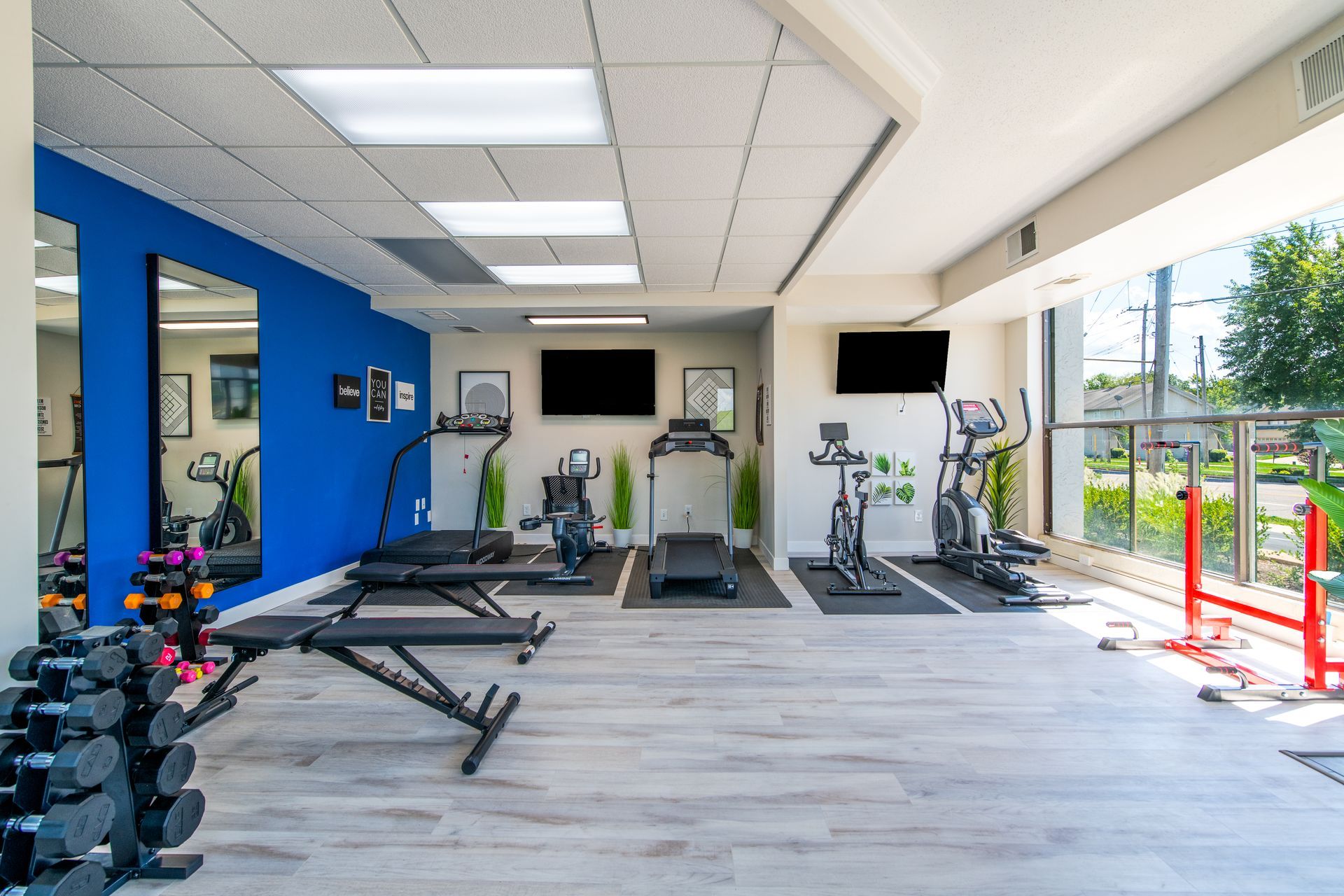 A large gym with a lot of equipment and a blue wall.