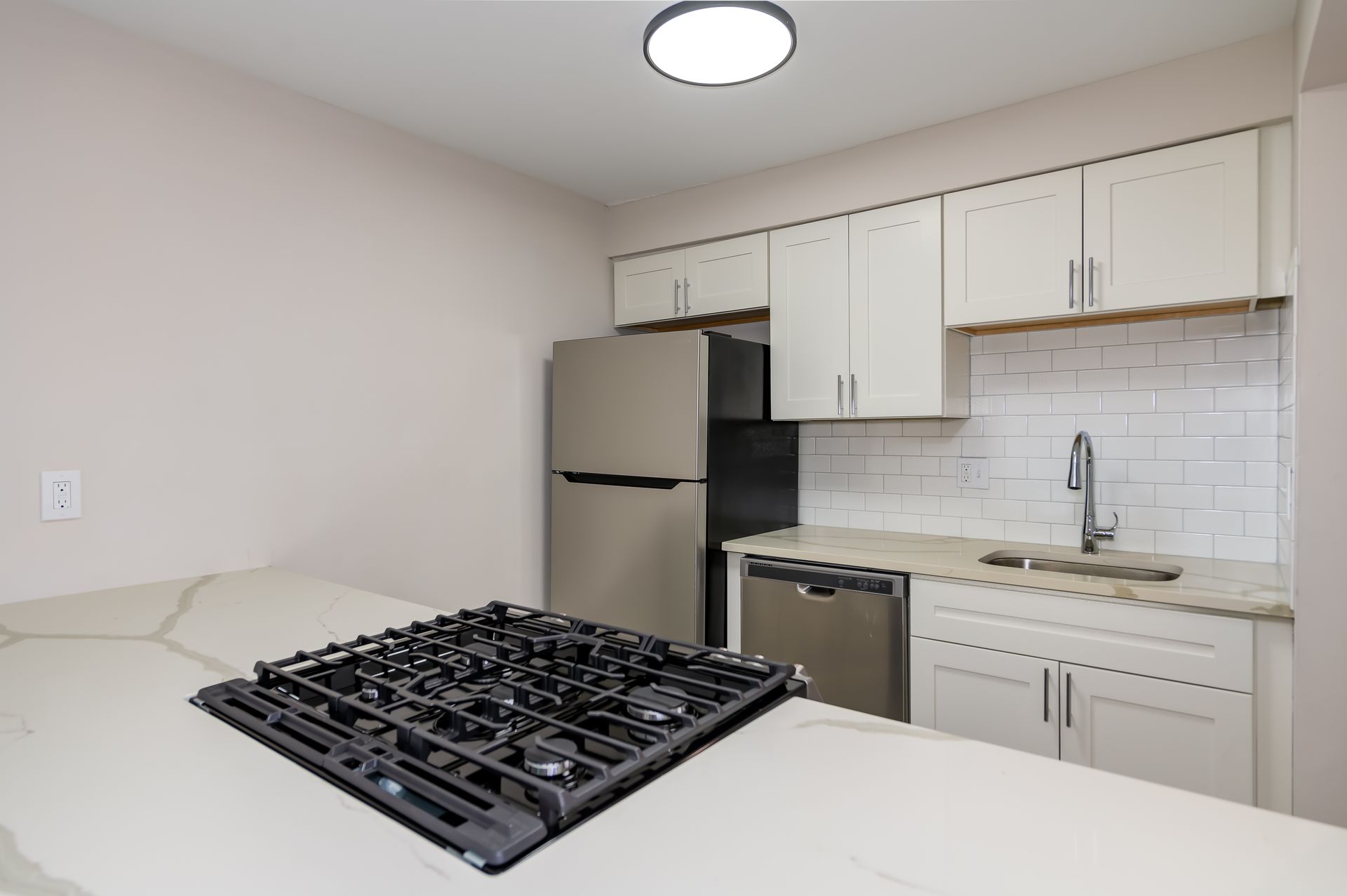 A kitchen with a stove top oven and a refrigerator