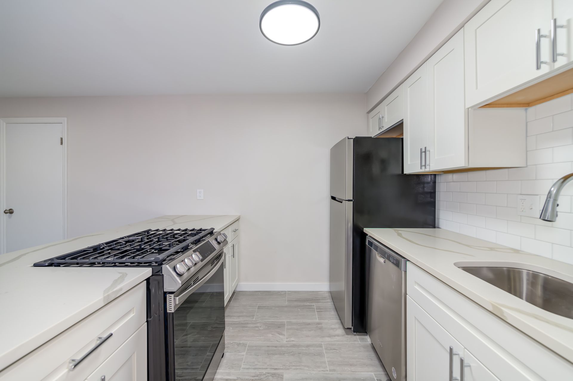 A kitchen with stainless steel appliances and white cabinets
