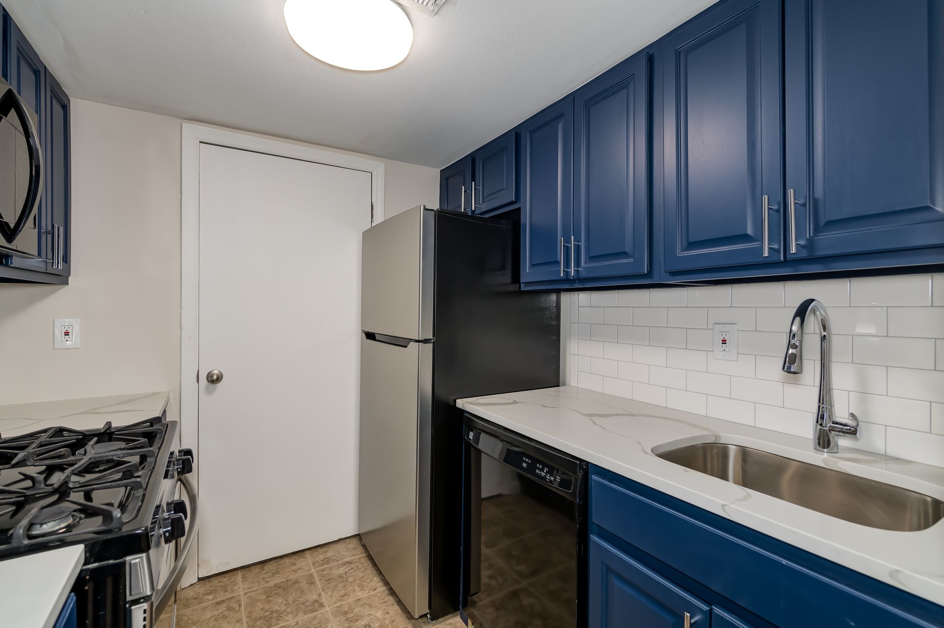 A kitchen with blue cabinets and stainless steel appliances