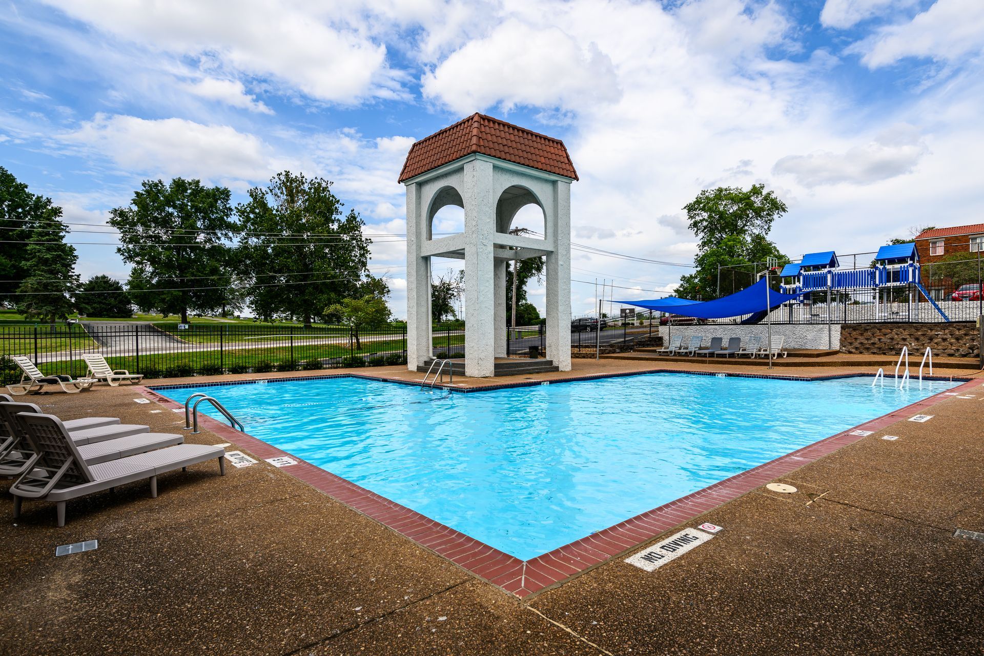 There is a large swimming pool with a water slide in the background.