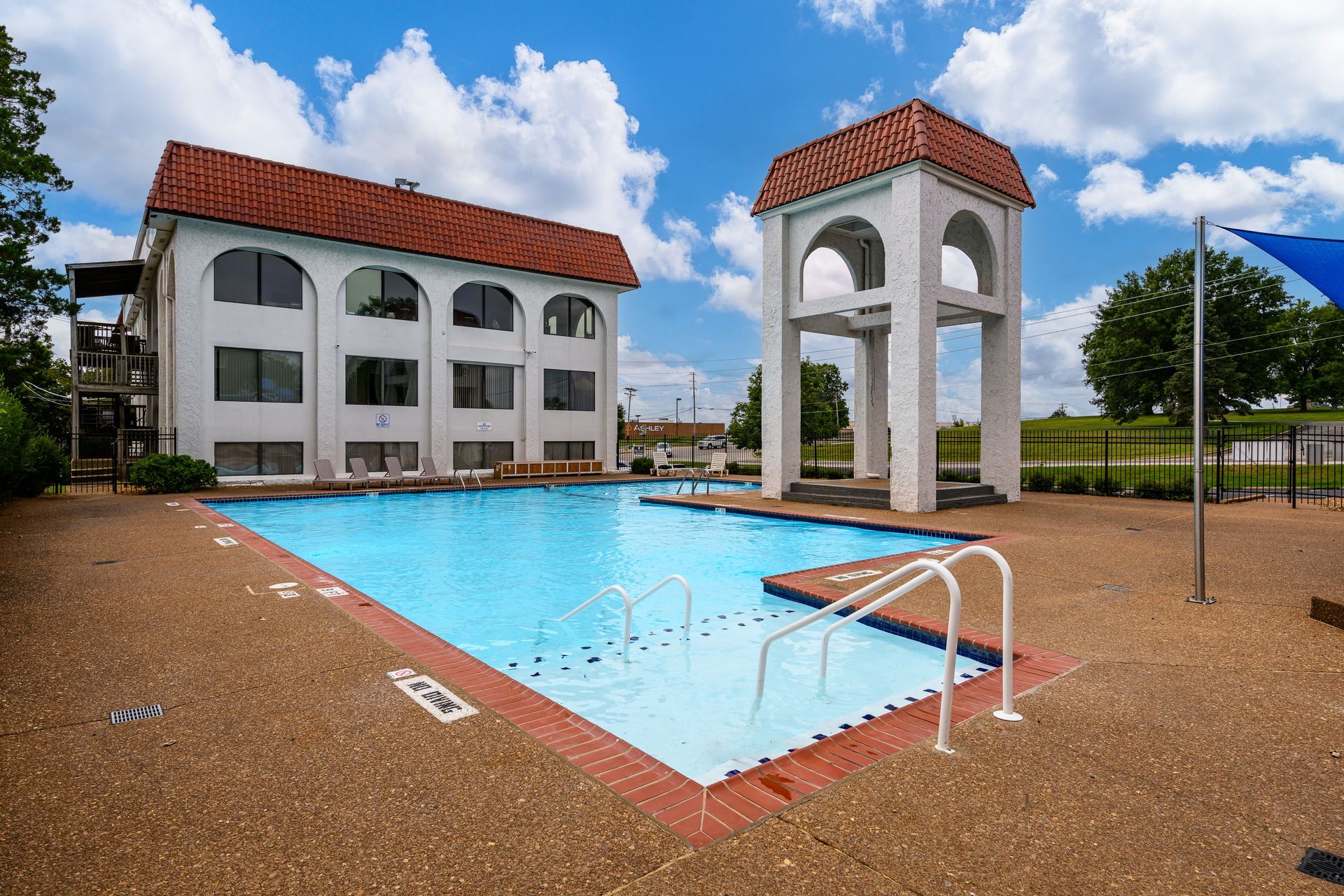 There is a large swimming pool in front of a building.