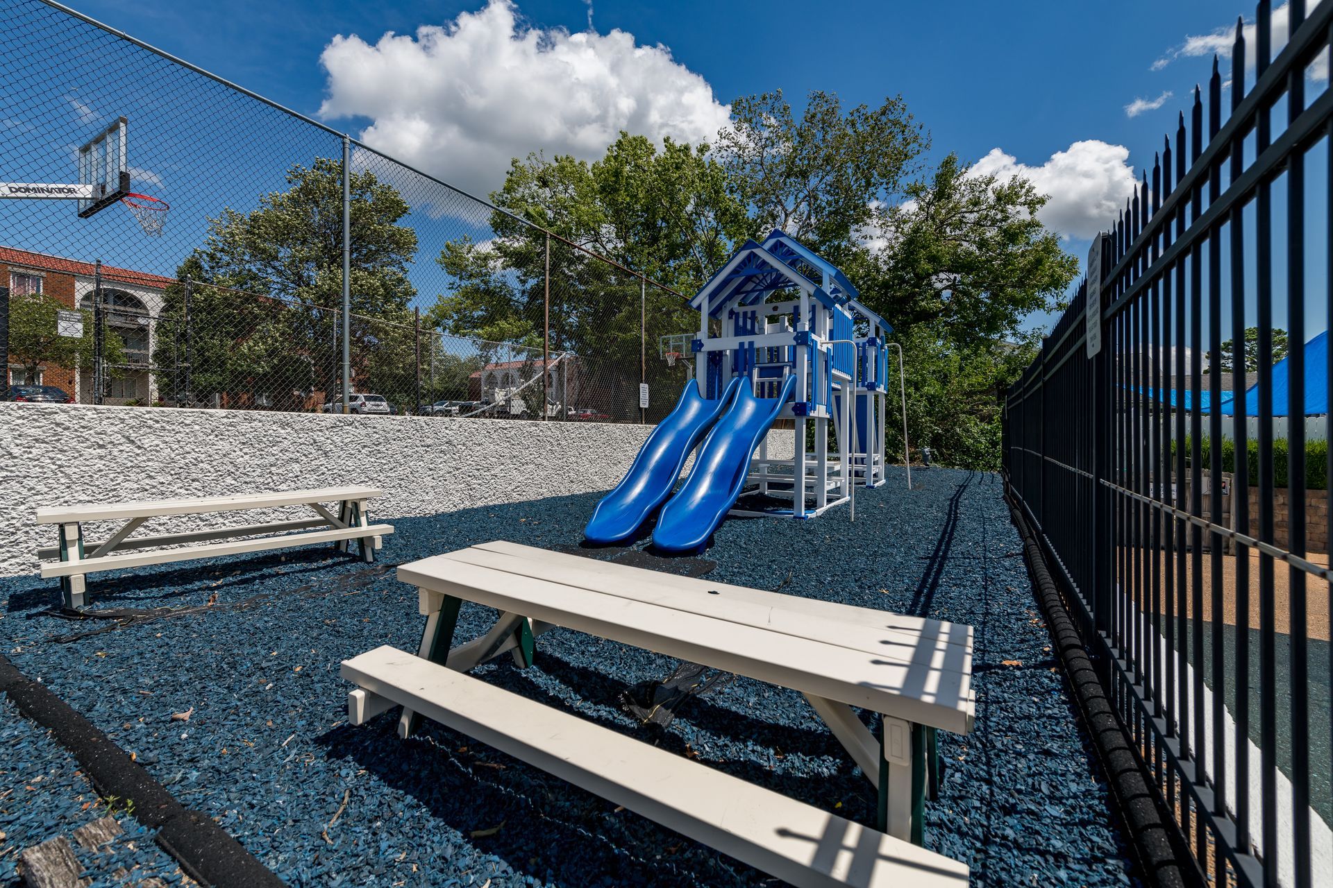There is a picnic table and a slide in the playground.