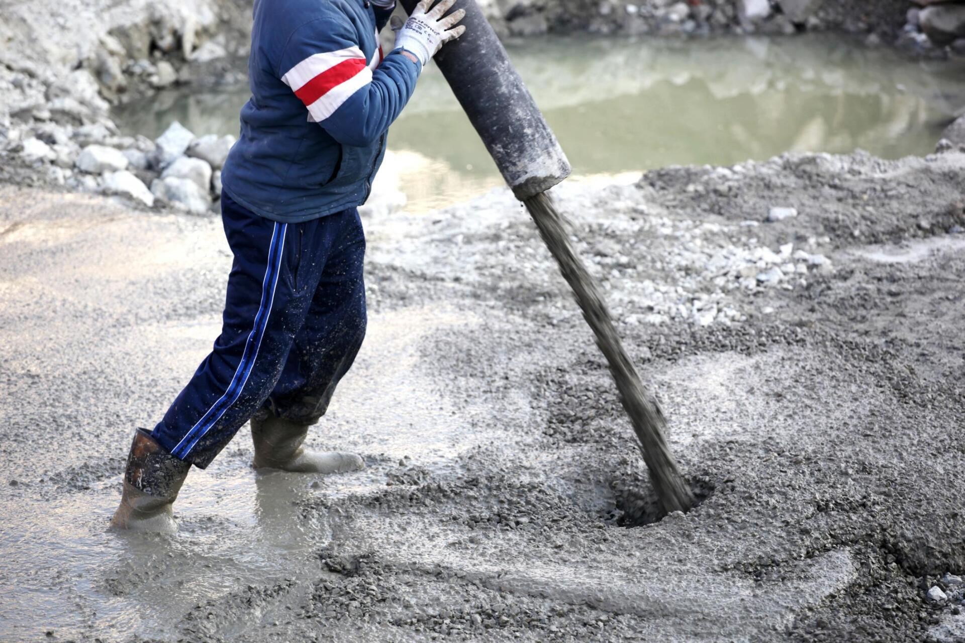 worker pouring fresh concrete cement