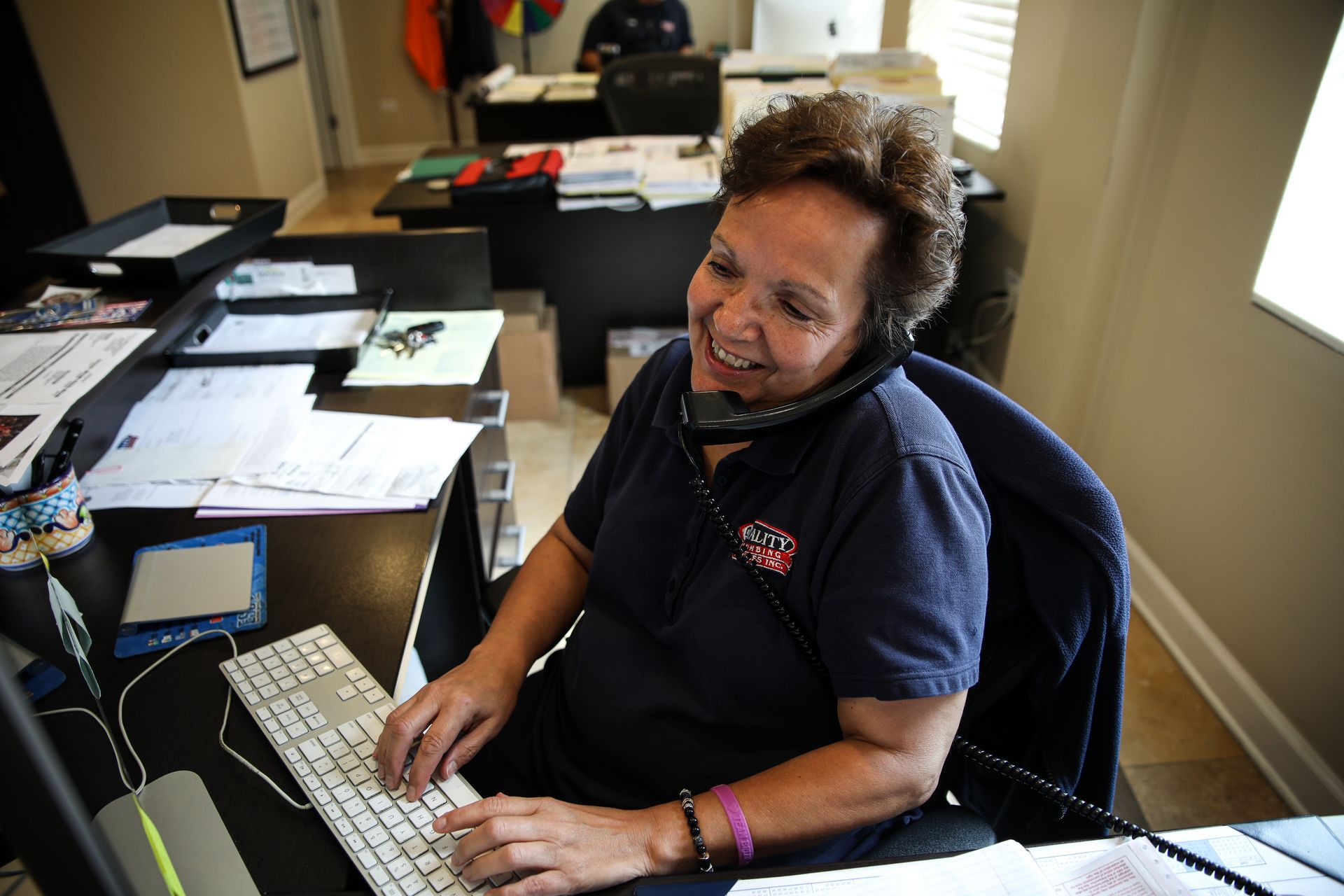 A customer service representative from Quality Plumbing Services Inc. Answering the phone and helping a customer.