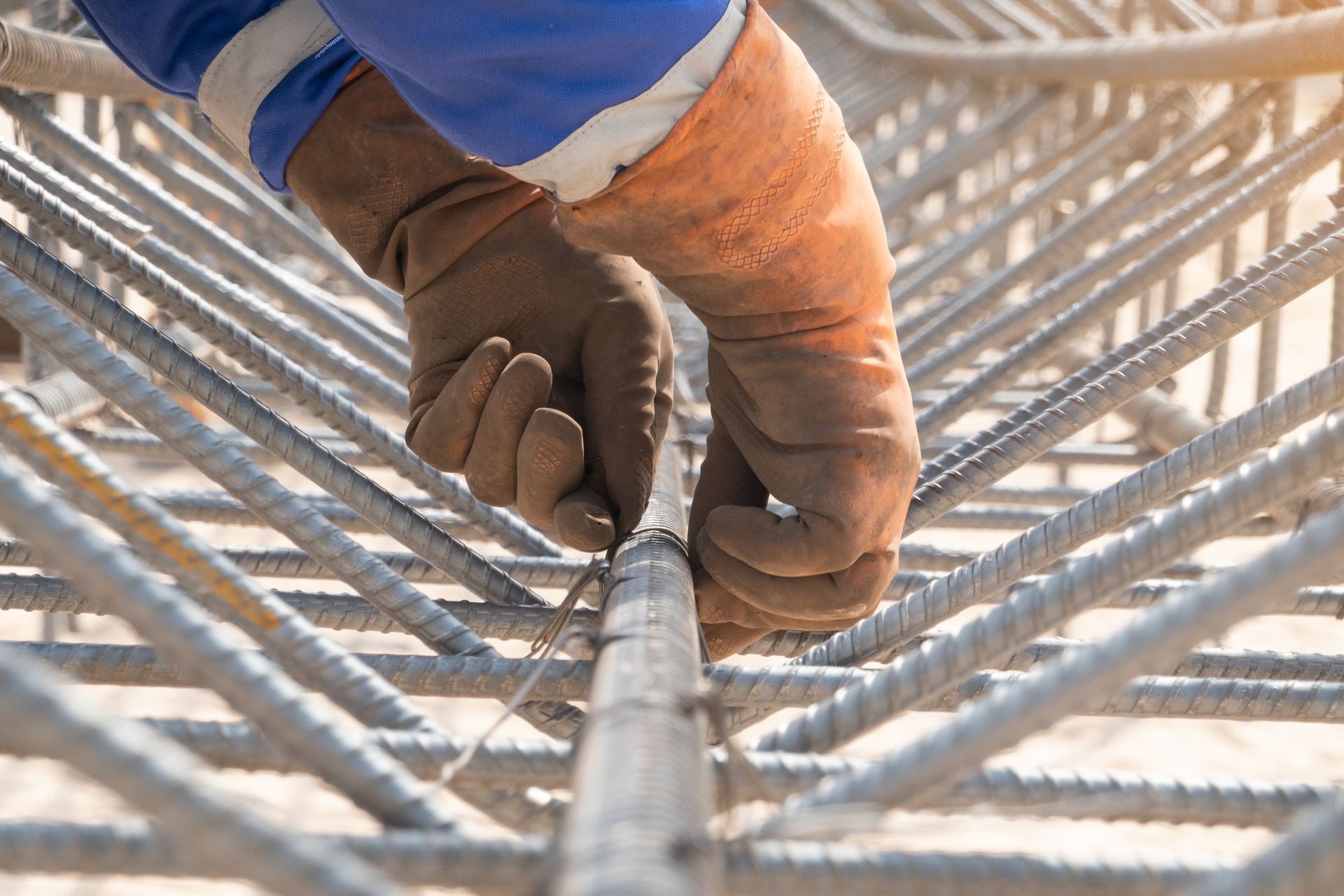 Contractor fixing a steel bar at a construction site, showcasing quality concrete formwork services.