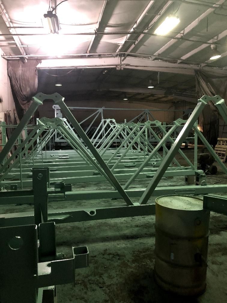 A warehouse filled with lots of metal structures and a barrel.