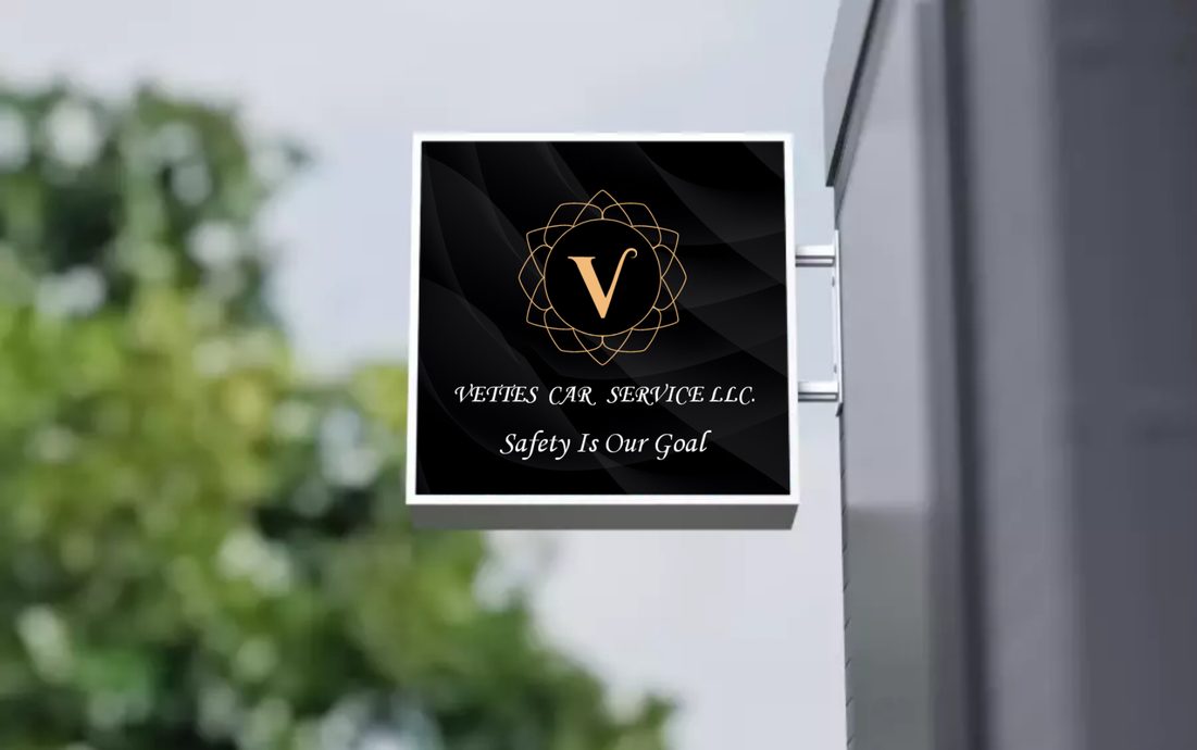 A black and gold sign with the letter v on it is hanging on a building.