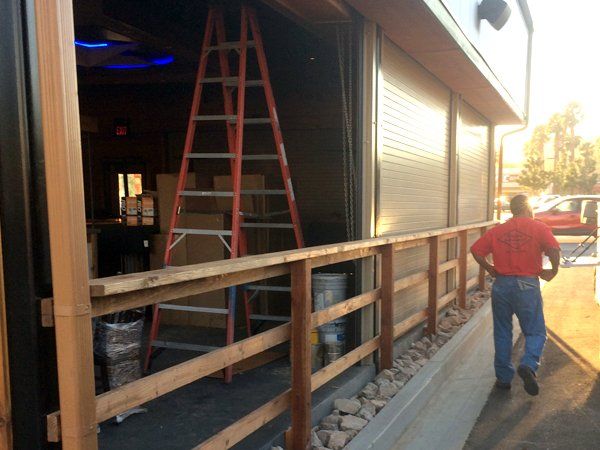 A man standing in front of a building with a ladder in the background