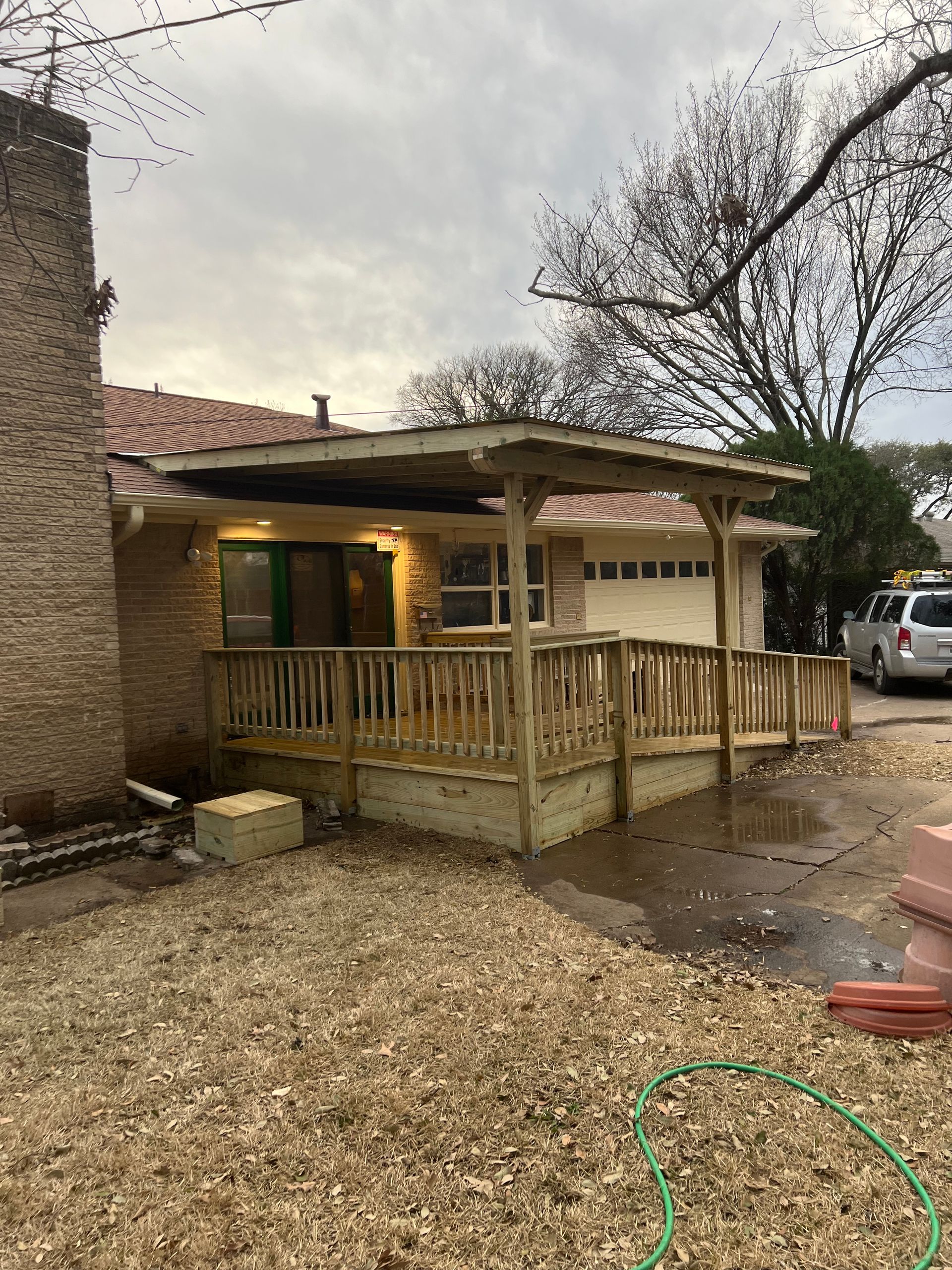 A wooden deck is being built in front of a house.