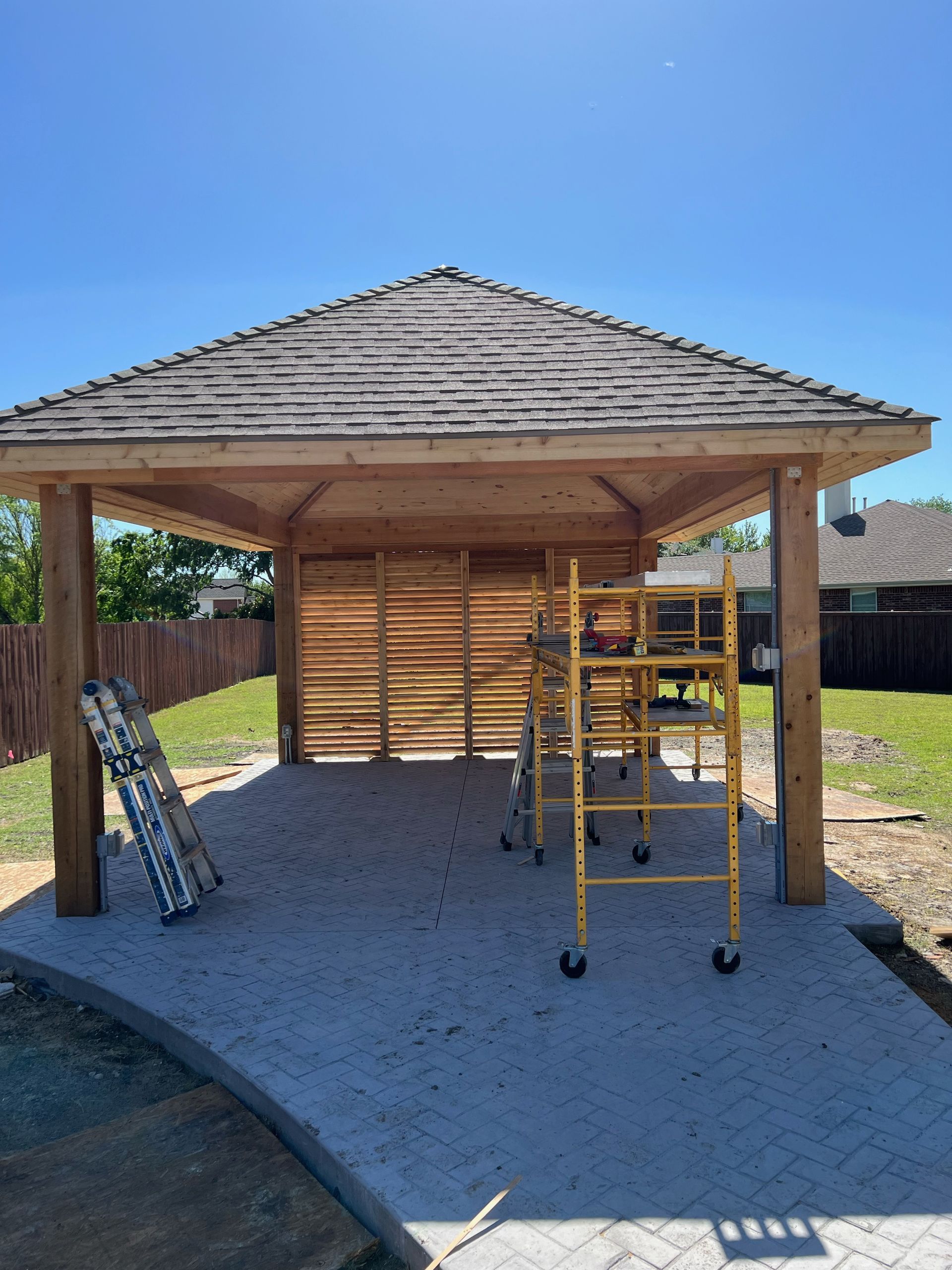 A wooden gazebo is being built in a backyard