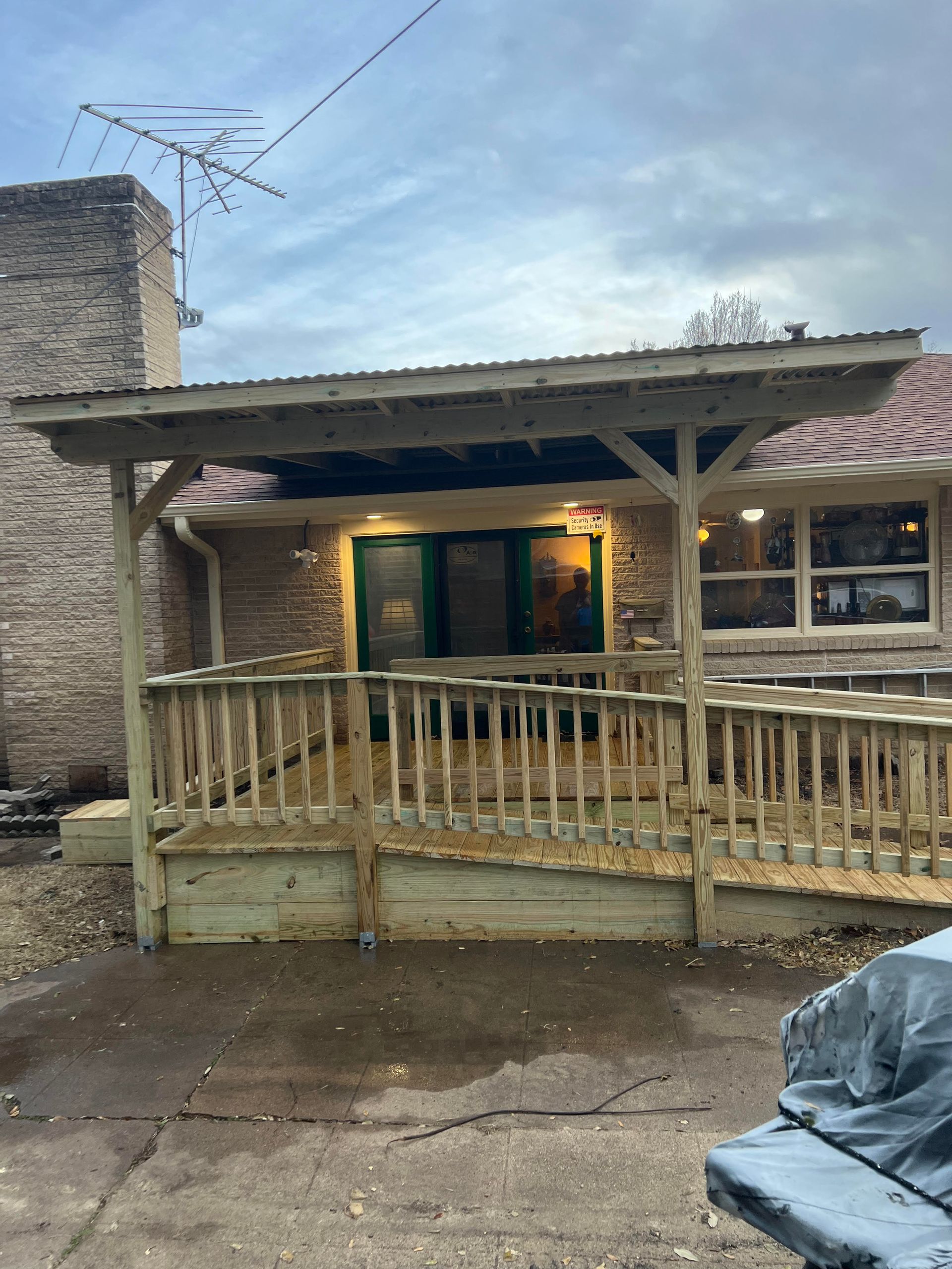 A house with a wooden deck and a covered porch.