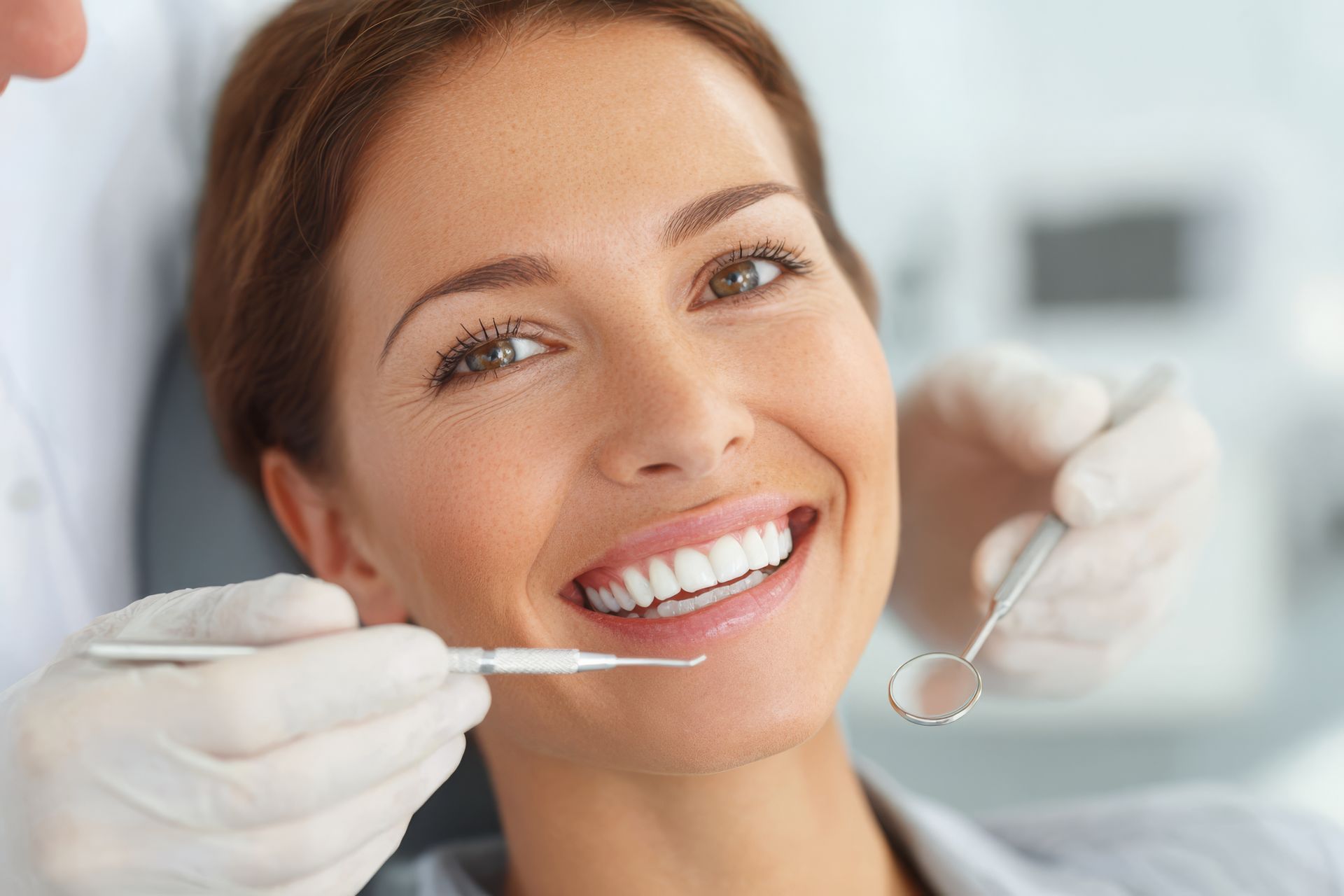 Happy patient receiving professional cosmetic dentistry treatment at a modern dental clinic.
