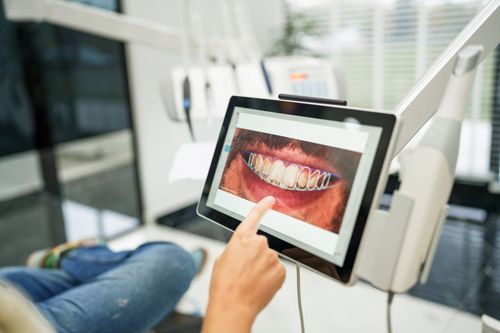 A patient looking at a tablet with an image of teeth-straightening in Glenn Mills, PA.