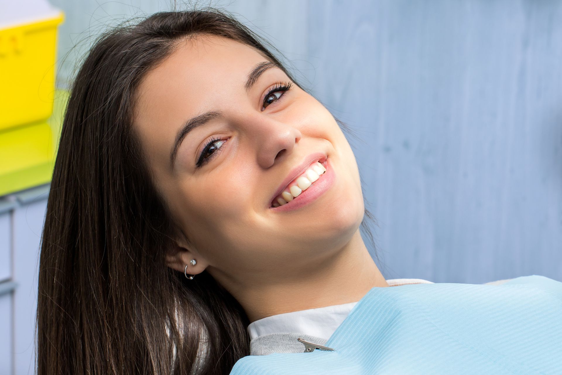 Person smiling with a blue background.