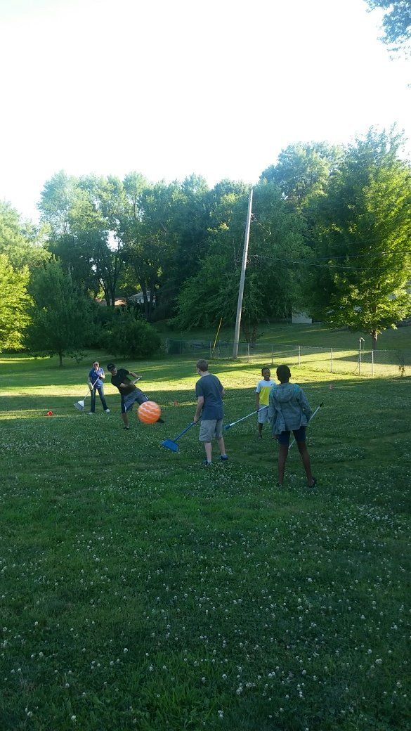 A group of people are playing soccer in a park.