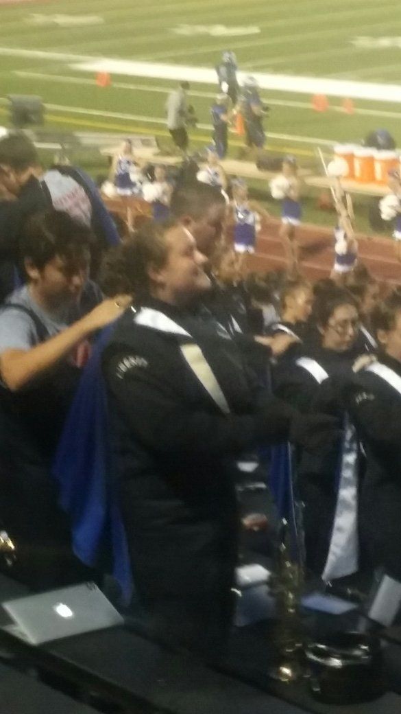 A group of people sitting in a stadium watching a football game