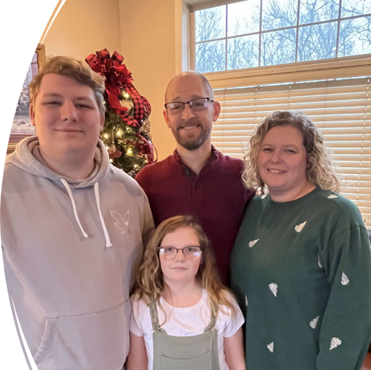 A family is posing for a picture in a gazebo decorated for christmas.