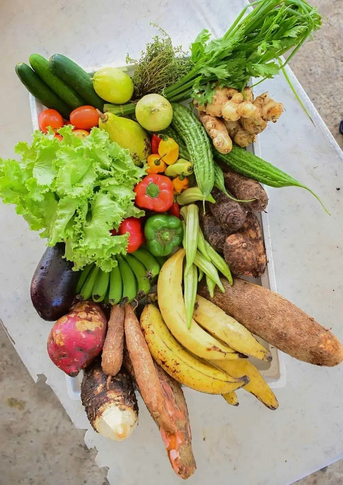 A bunch of fruits and vegetables are sitting on a table.