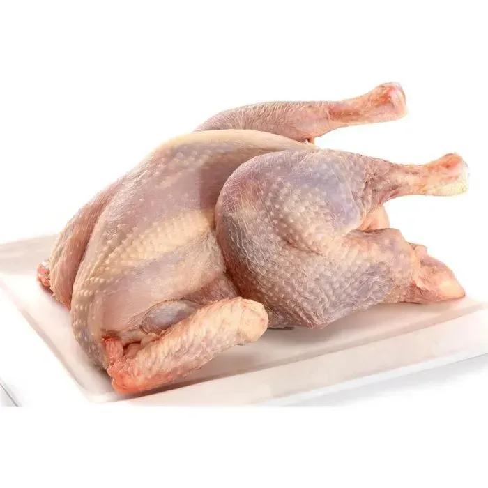 A raw chicken is sitting on a white plate.