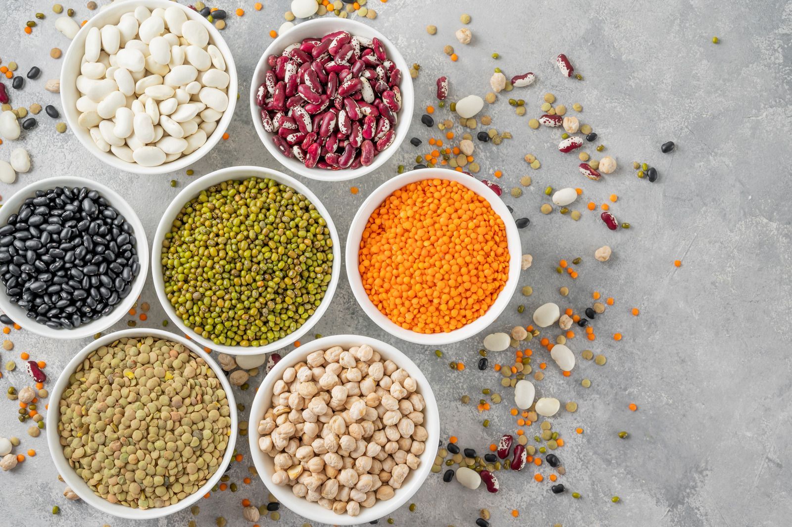 There are many different types of beans in the bowls.