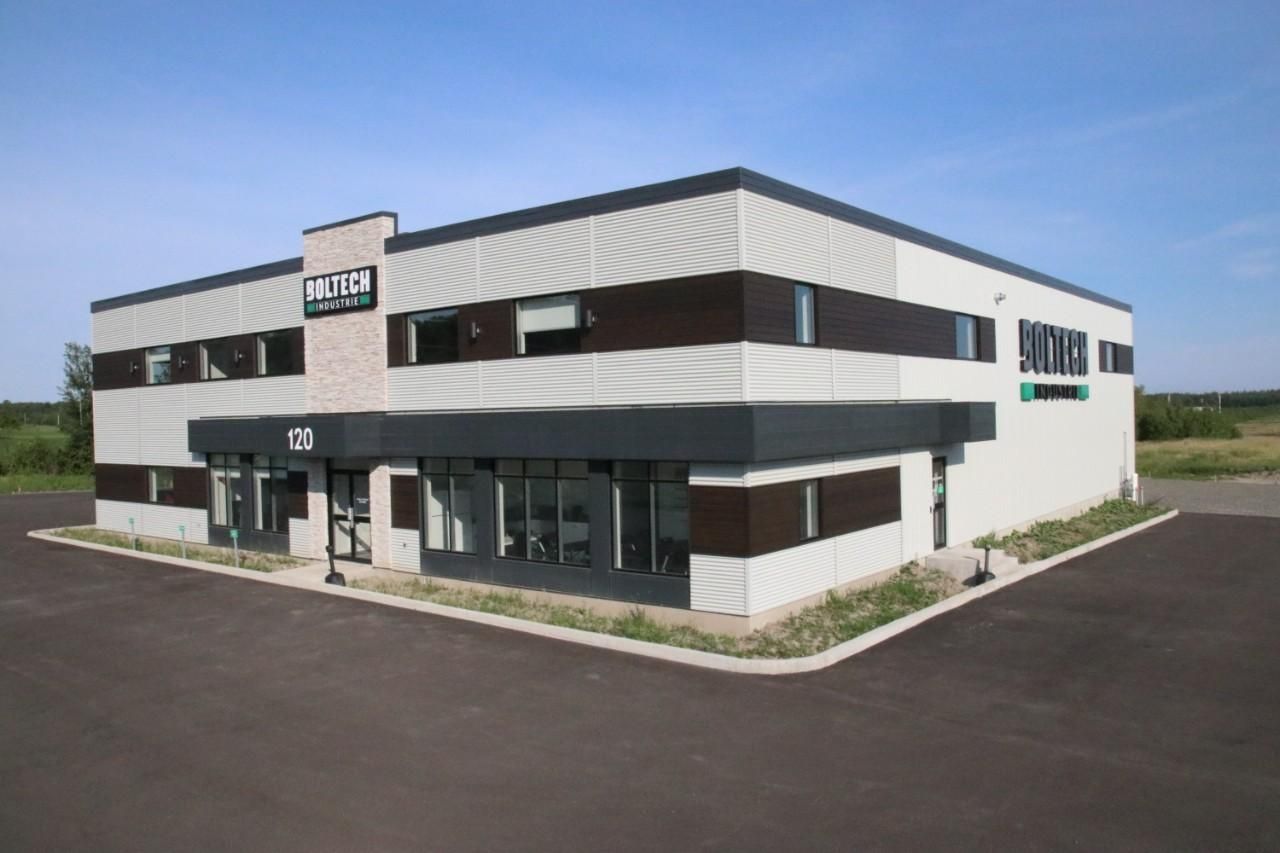 Bâtiment commercial moderne de deux étages avec des accents noirs et bruns par une journée ensoleillée.