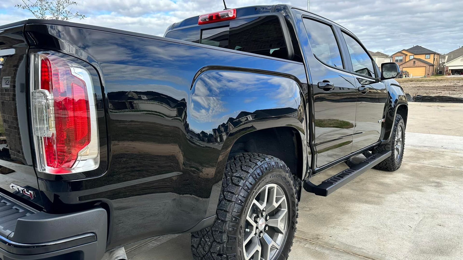 Black pickup truck parked on pavement, shiny paint, outdoor daylight.