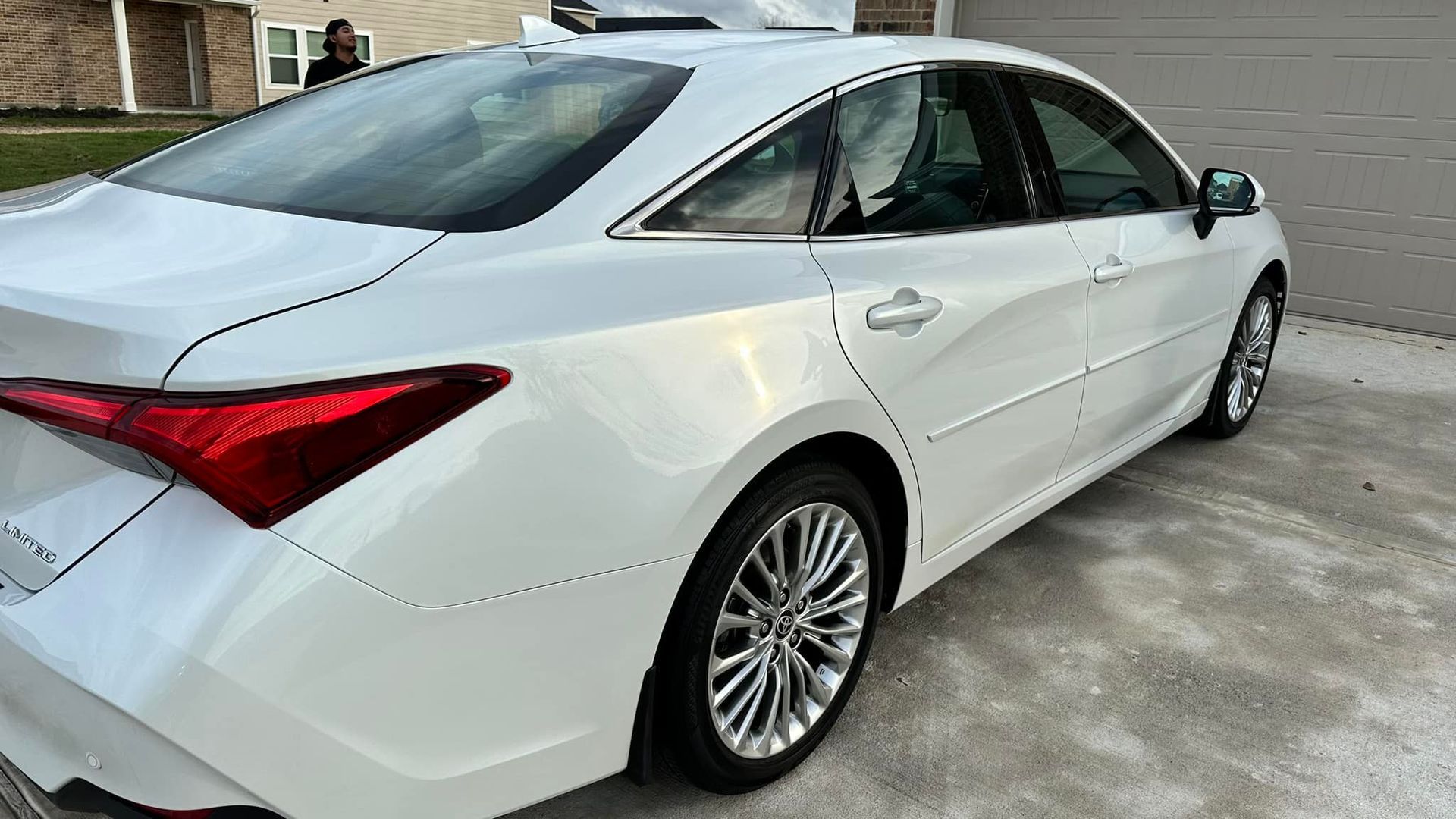 White Toyota Avalon sedan parked on concrete driveway.